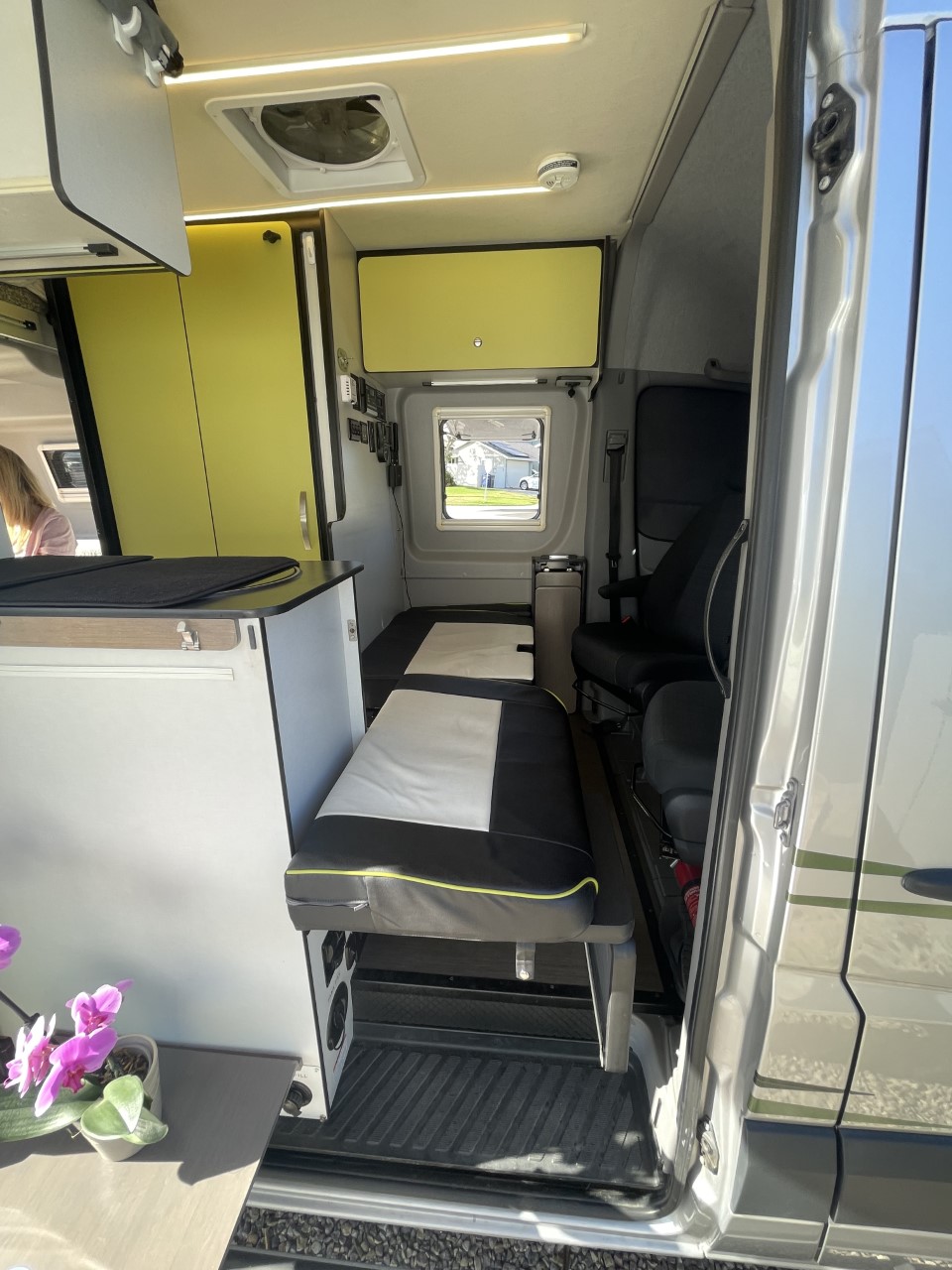Inside an RV rental: modern yellow cabinets, comfortable bench seating, and smart design for versatile mobile living.. Winnebago Revel 2019