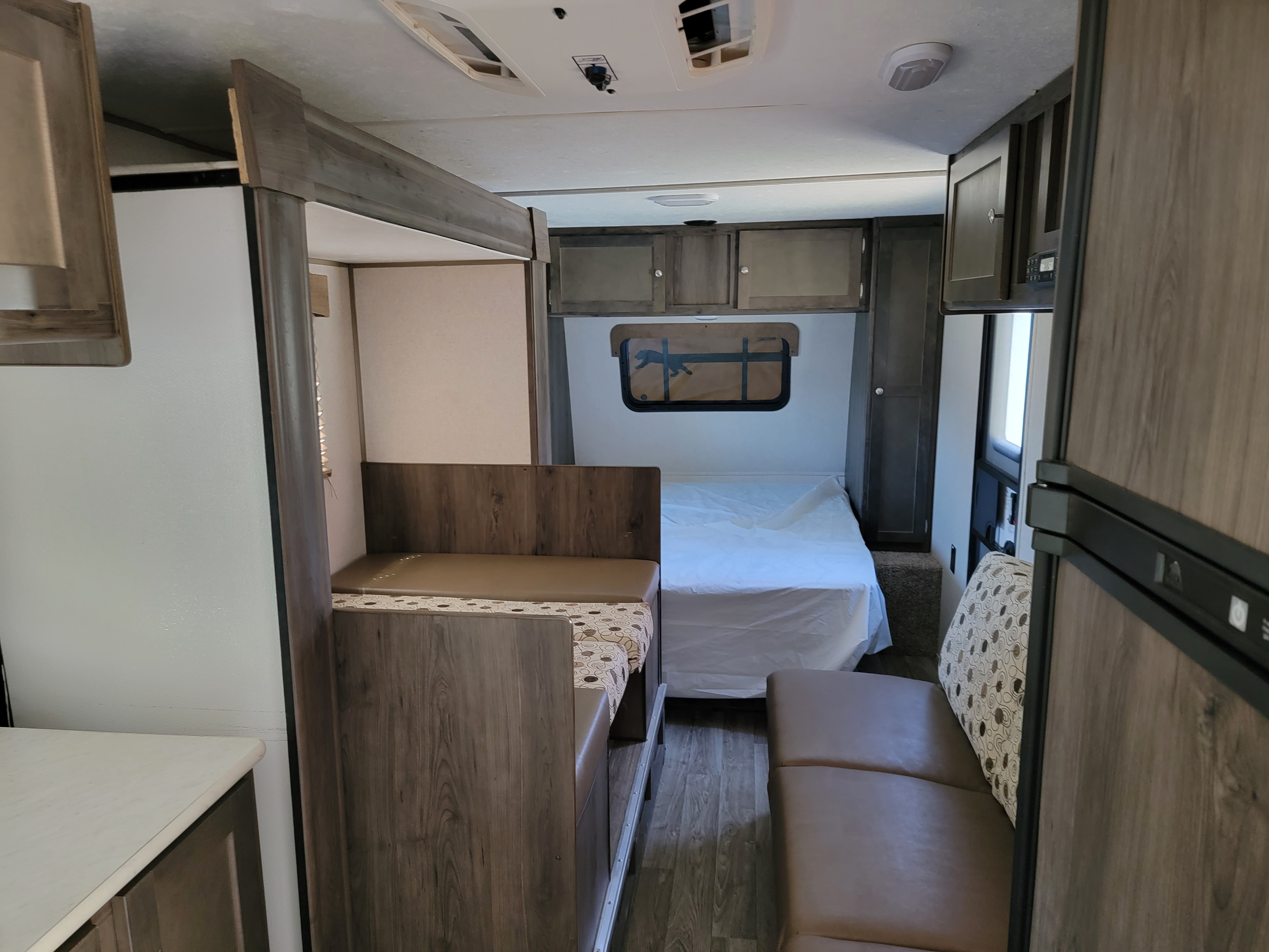 RV rental interior featuring a dinette, bed, refrigerator, and wood-grain cabinets for a comfortable journey.. Clipper Clipper Trailer 2019