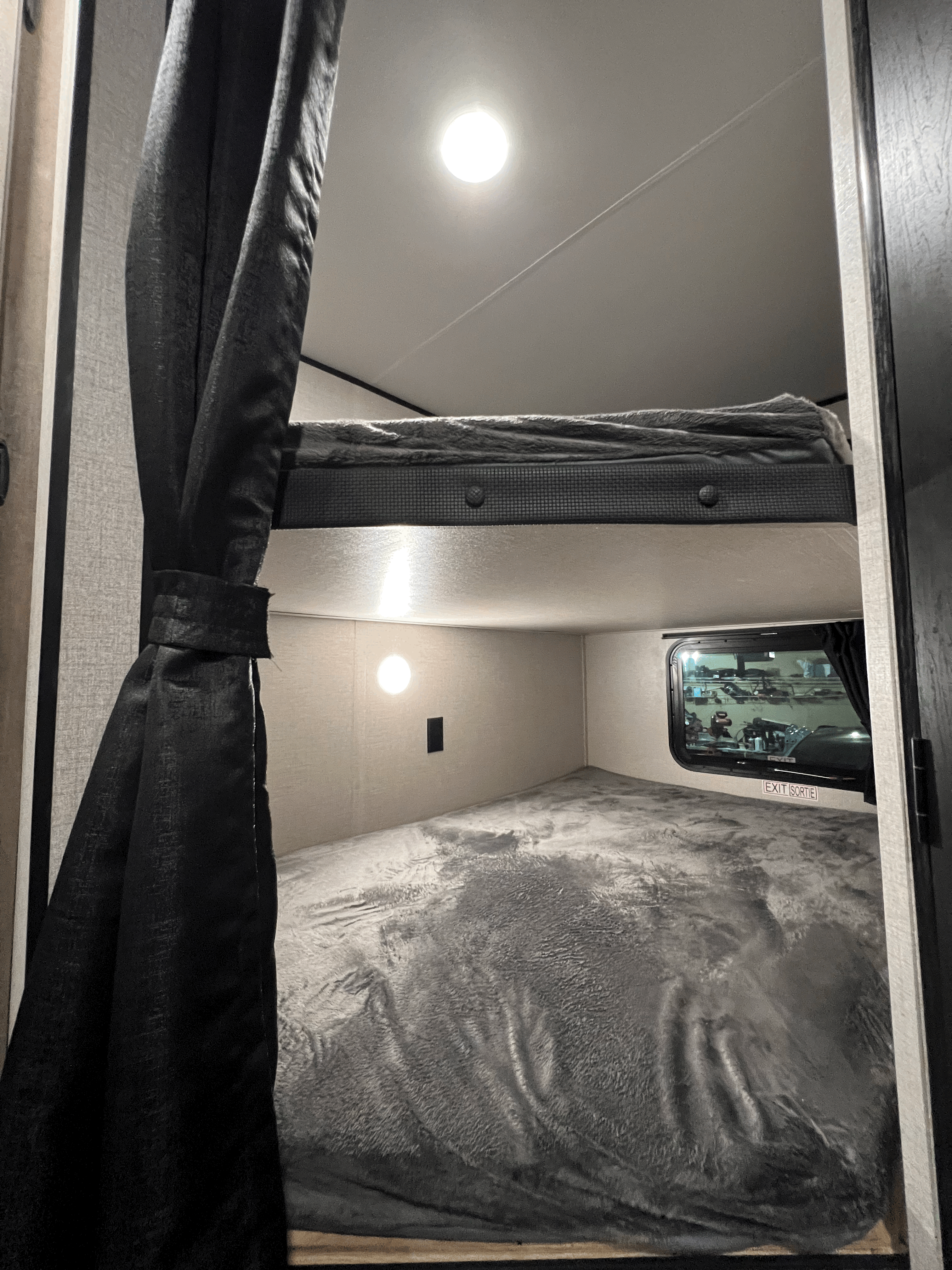 Experience the comfort of our RV rental with cozy bunk beds! This sleeping area features two levels, a window, and lights.. Starcraft Autumn Ridge 2022
