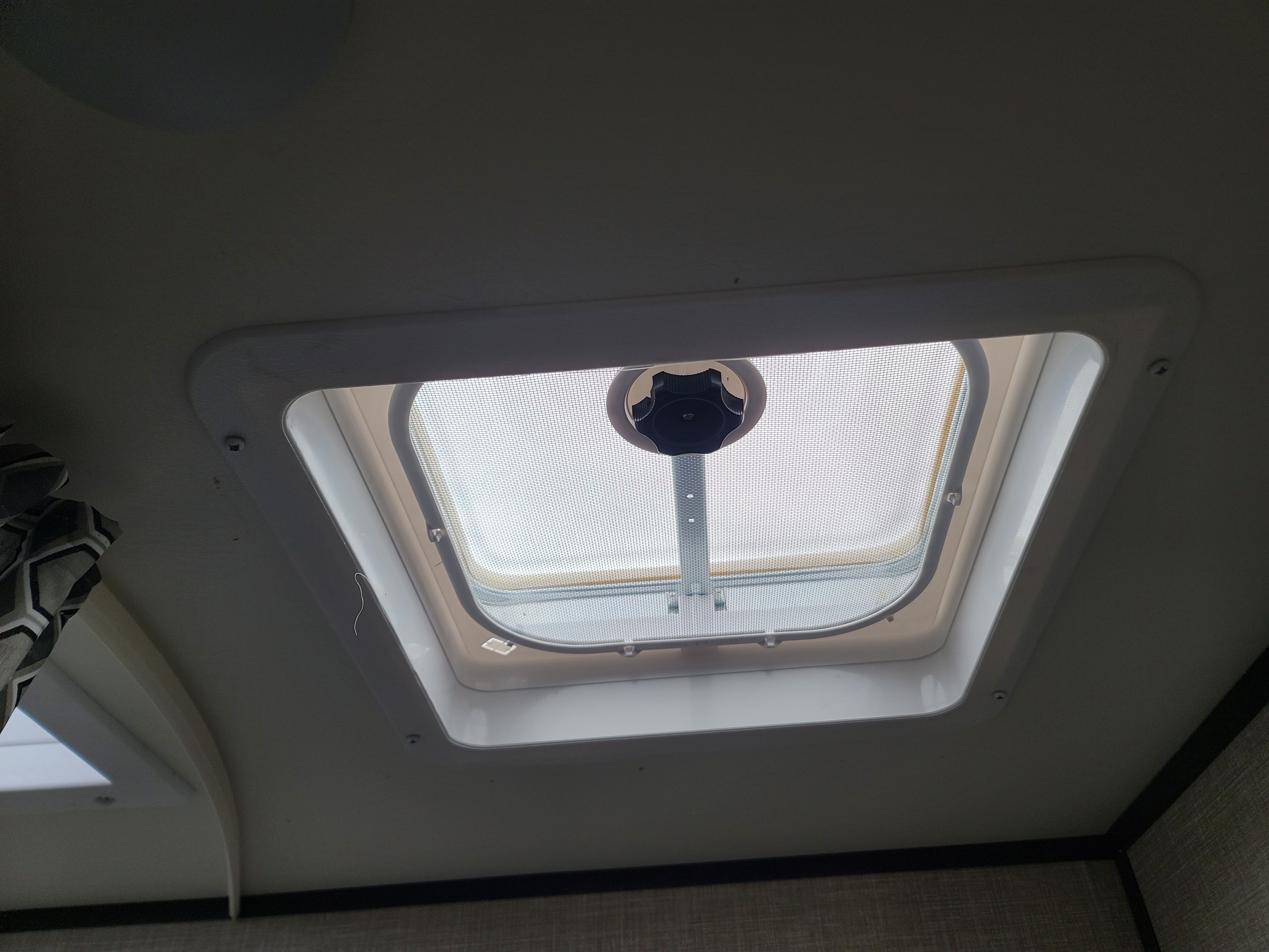 Inside an RV rental: a ceiling vent with mesh screen and crank for airflow.. Jayco Jayco 2022