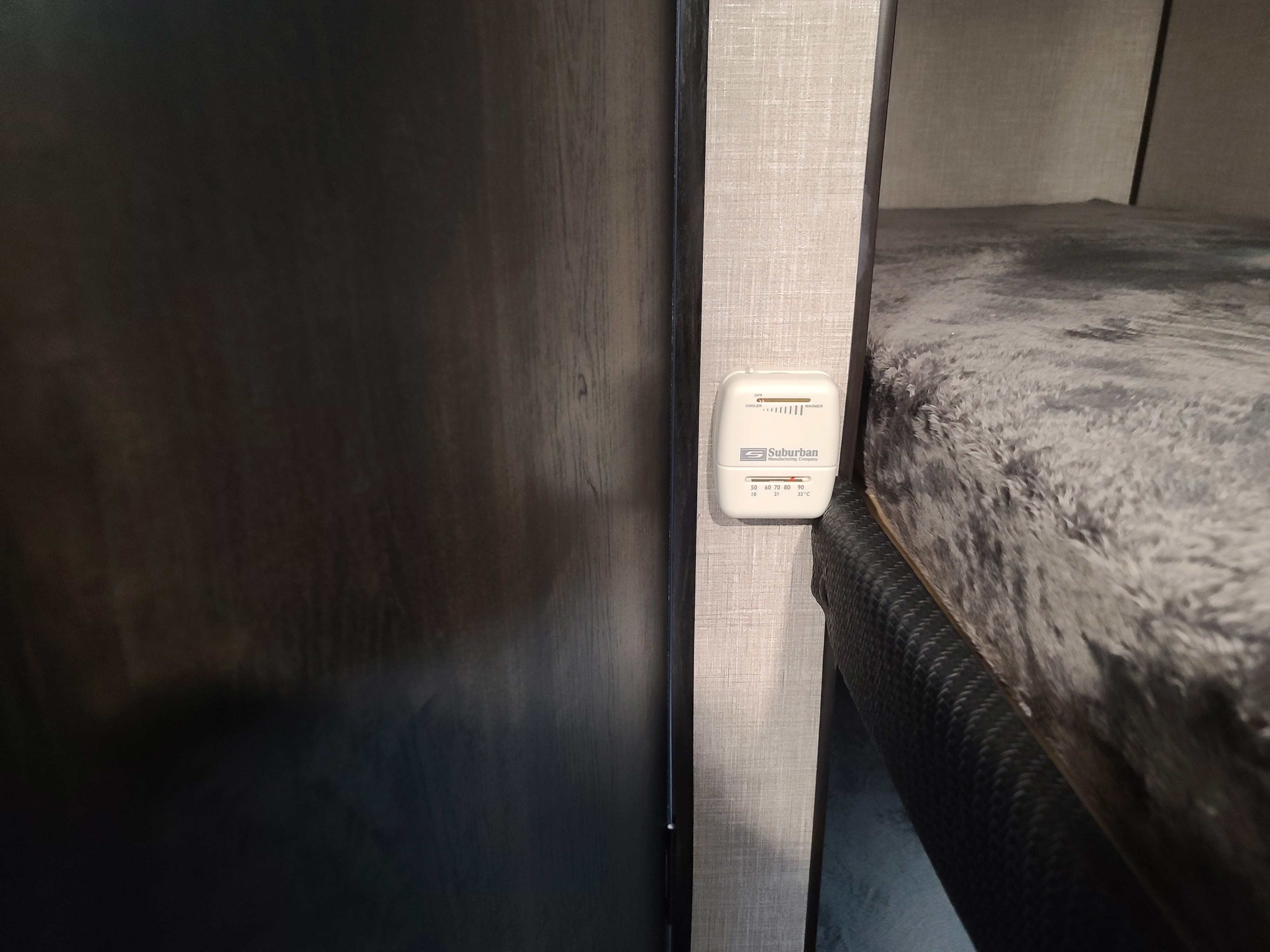 Suburban RV thermostat for climate control, seen in an rv rental, located next to a bunk area.. Jayco Jayco 2022