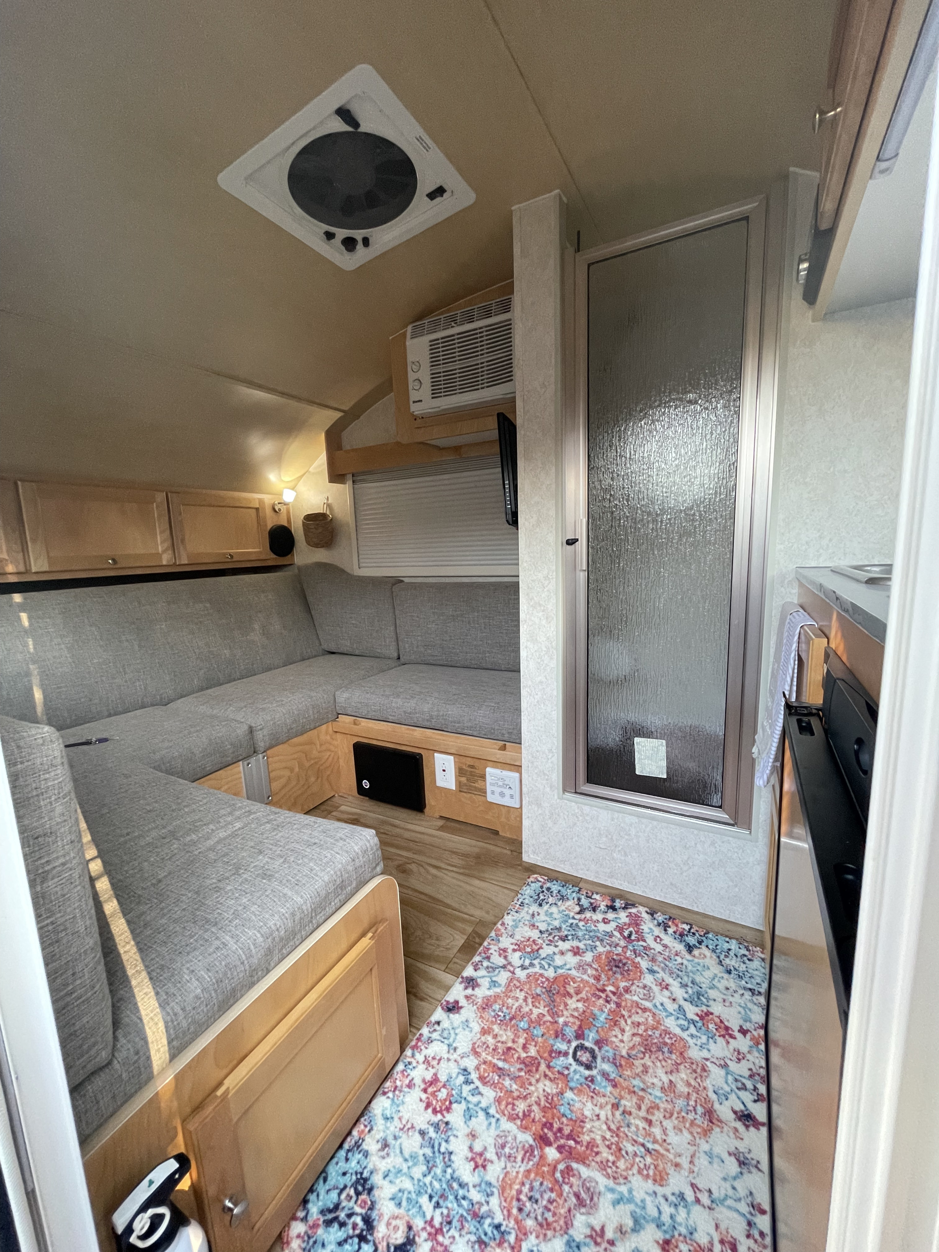 RV rental interior: A cozy U-shaped lounge, compact kitchen, bathroom, and air conditioning for comfortable adventures.. nuCamp T@B 2018