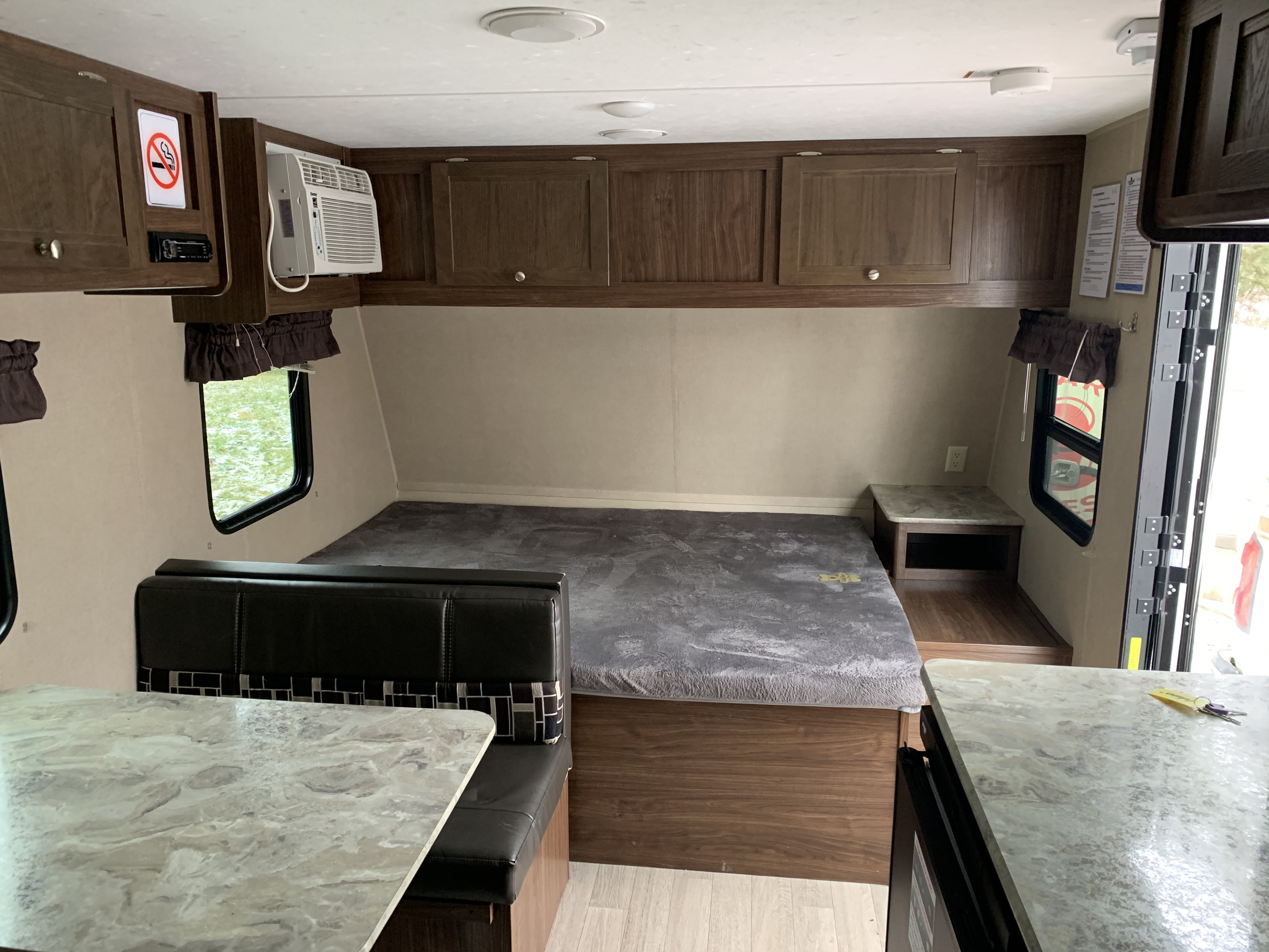 This RV rental interior offers a bed, dining booth, AC, and stereo with overhead storage. Ready for your next adventure.. Coleman 17F 2017