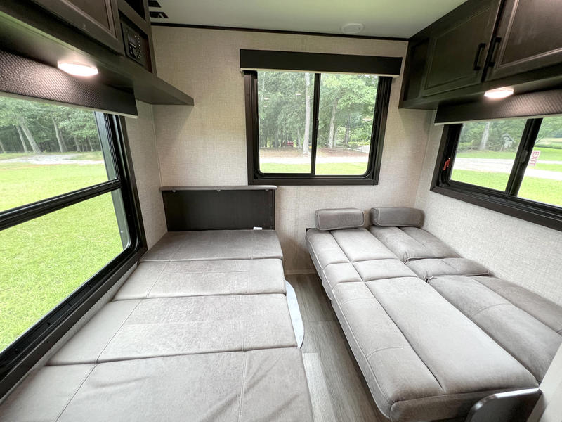 RV rental interior: two comfortable beds, large windows, and a green campground view. Perfect for travel.. jayco Jay Flight 2022