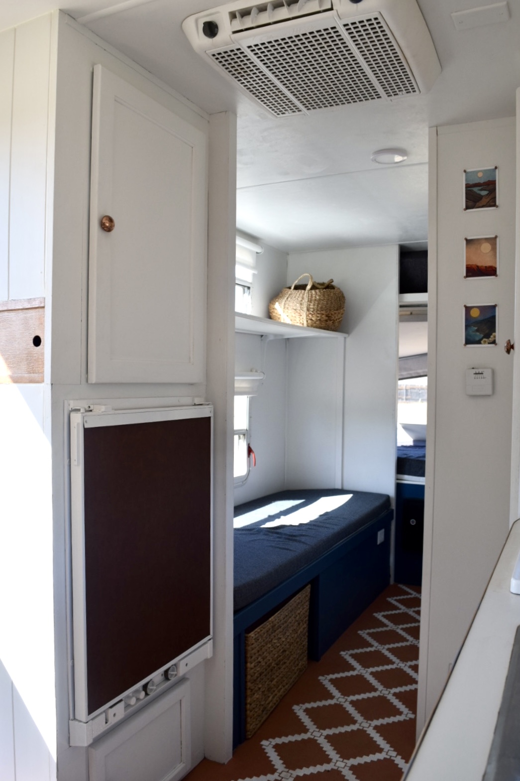 Bright RV rental interior: compact bunk area, fold-down table, & AC unit, featuring a modern, clean design.. Aerolite Cub 1999