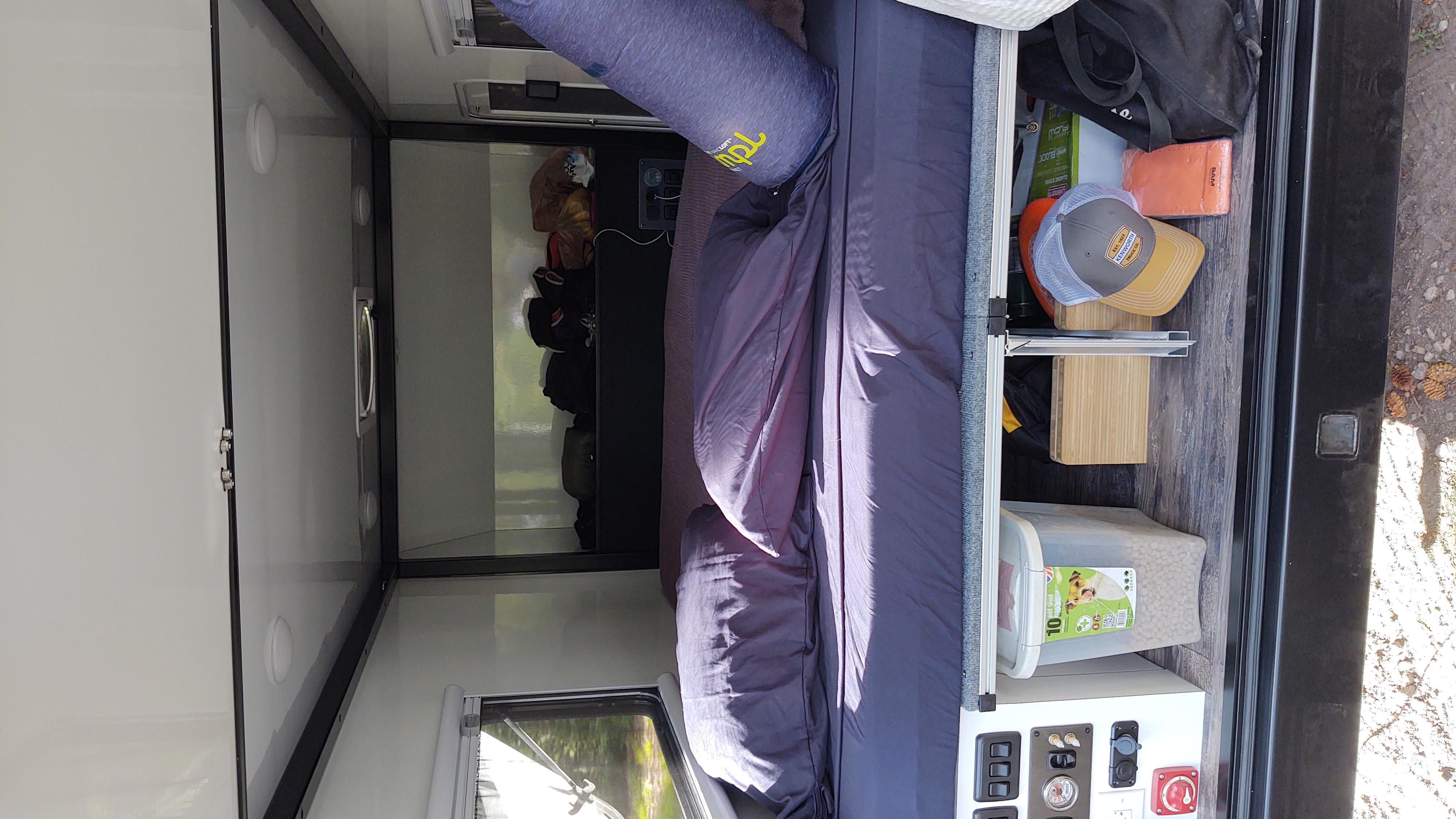 Cozy RV rental interior with bed, pet food, and control panel for comfortable travel.. TetonX Porter 2022