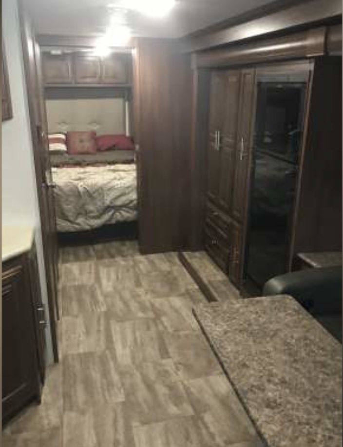 Cozy RV rental interior showing a modern bedroom, patterned flooring, and built-in storage. Perfect for comfortable travel.. Georgetown Georgetown Motorhome 2017