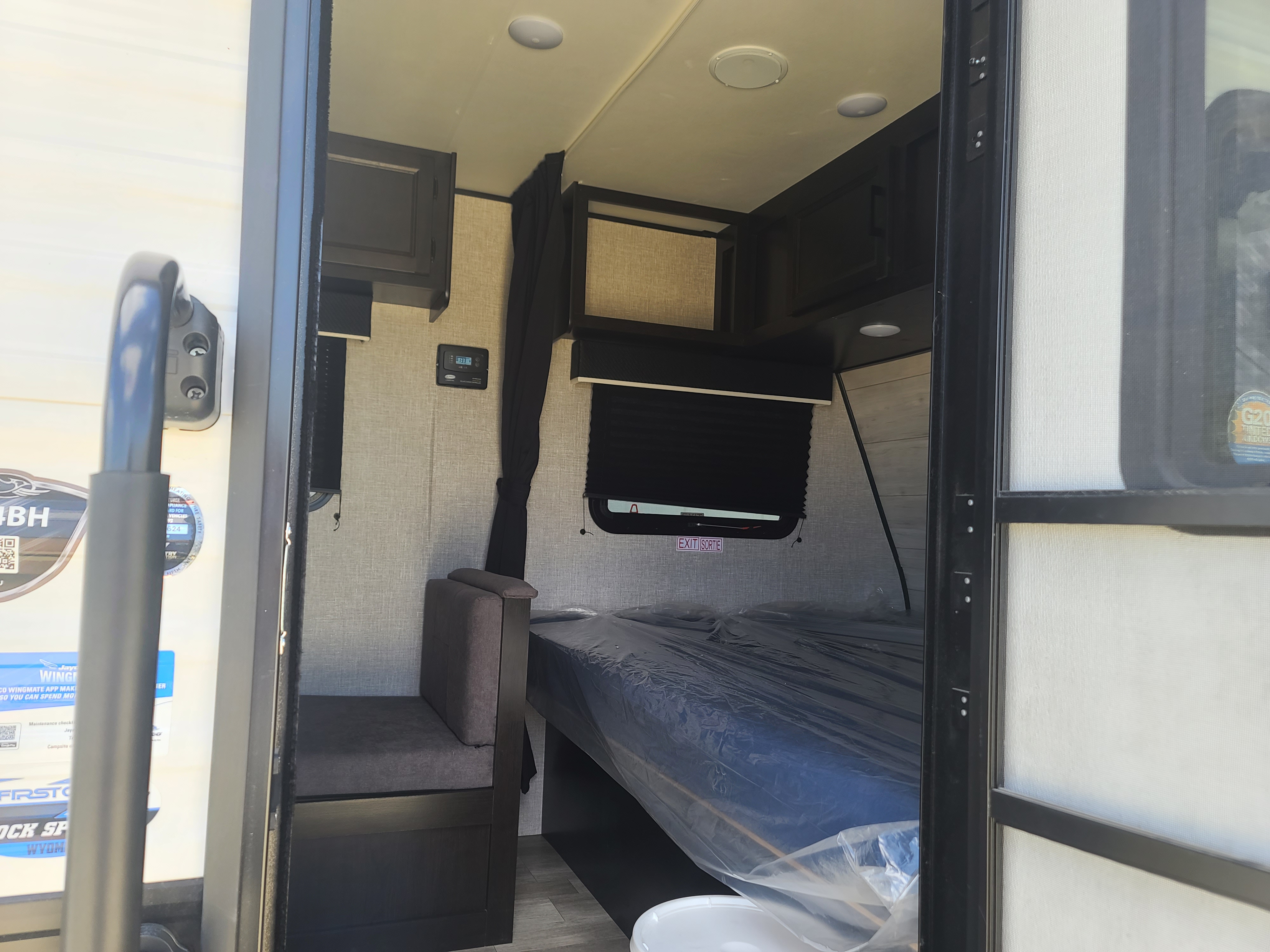 RV rental interior showing compact bed area, dinette, and overhead cabinets for comfortable travel.. Jayco Baja 174 2022