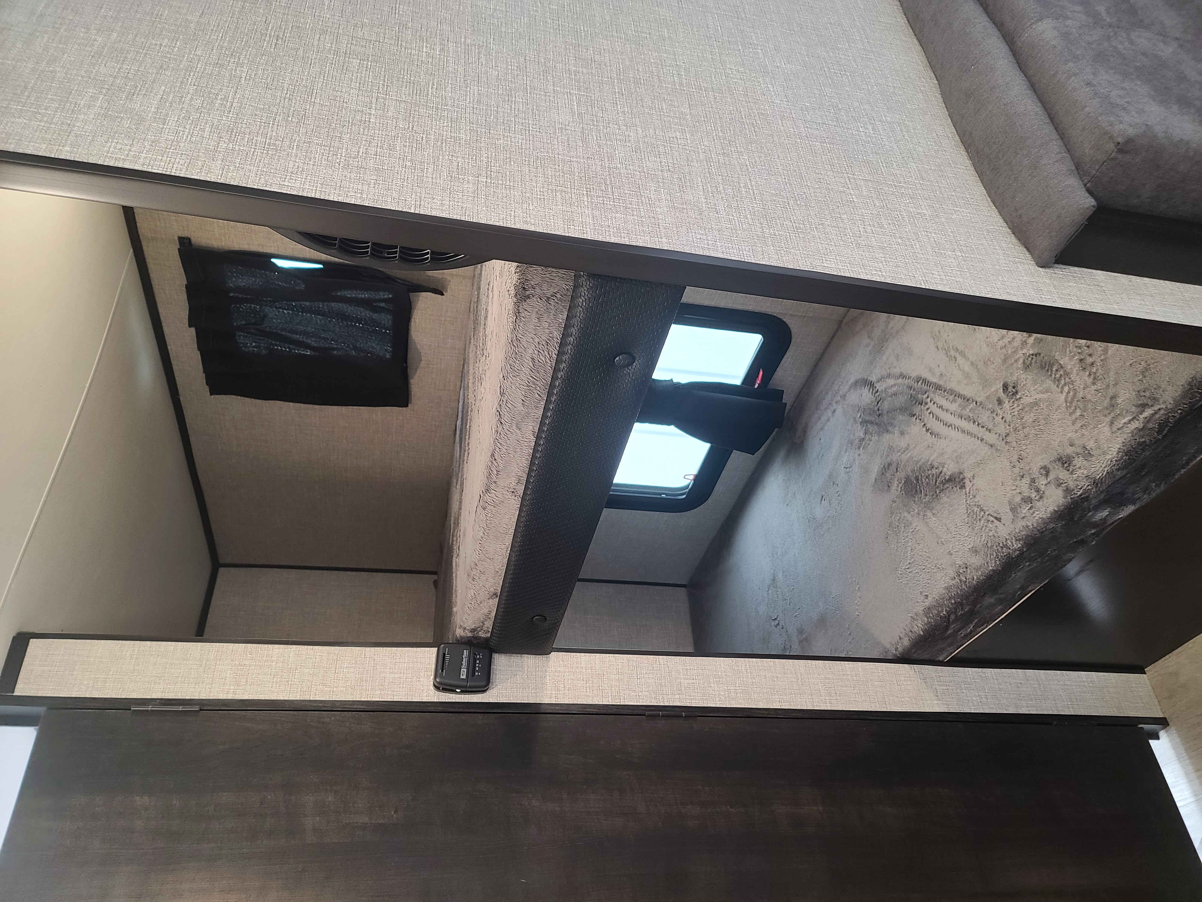 Cozy RV rental bunk beds in a compact travel trailer. Features textured walls, a small window, and modern interior finishes.. Jayco Baja 174 2022