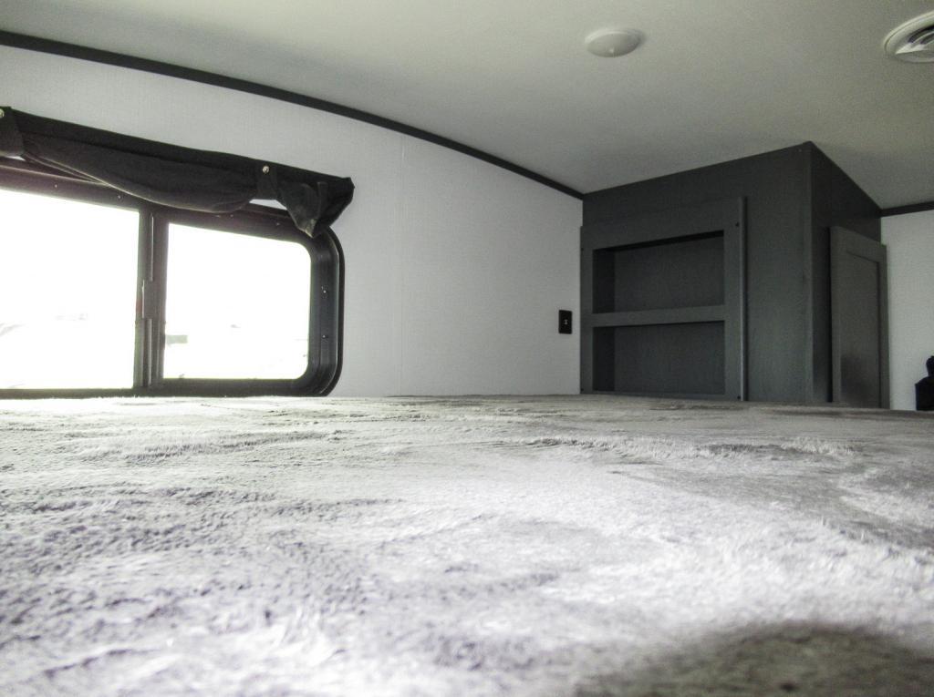 Experience comfort in this RV rental's cozy bunk area, featuring a plush bed, window, and built-in storage.. Keystone RV Bullet Ultra Lite 2022