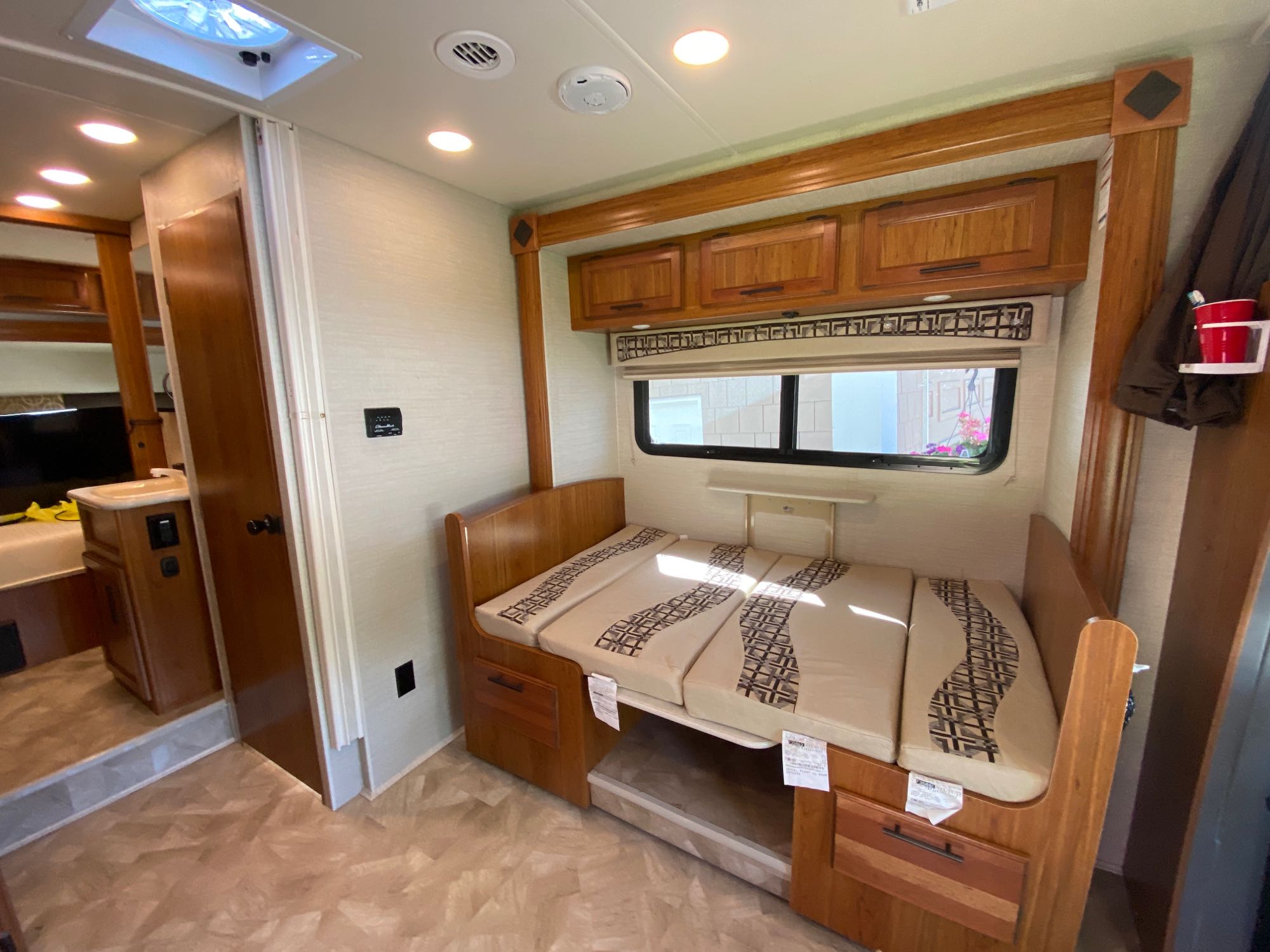 RV rental interior: A functional bunk bed sleeping area with patterned cushions, overhead storage, and window for travel comfort.. Jayco Melbourne 2017