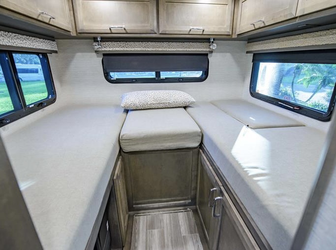 Inside this RV rental: a compact sleeping area with two parallel beds, a central cushioned bench, and windows.. Tiffin Motorhomes Wayfarer LW 2023