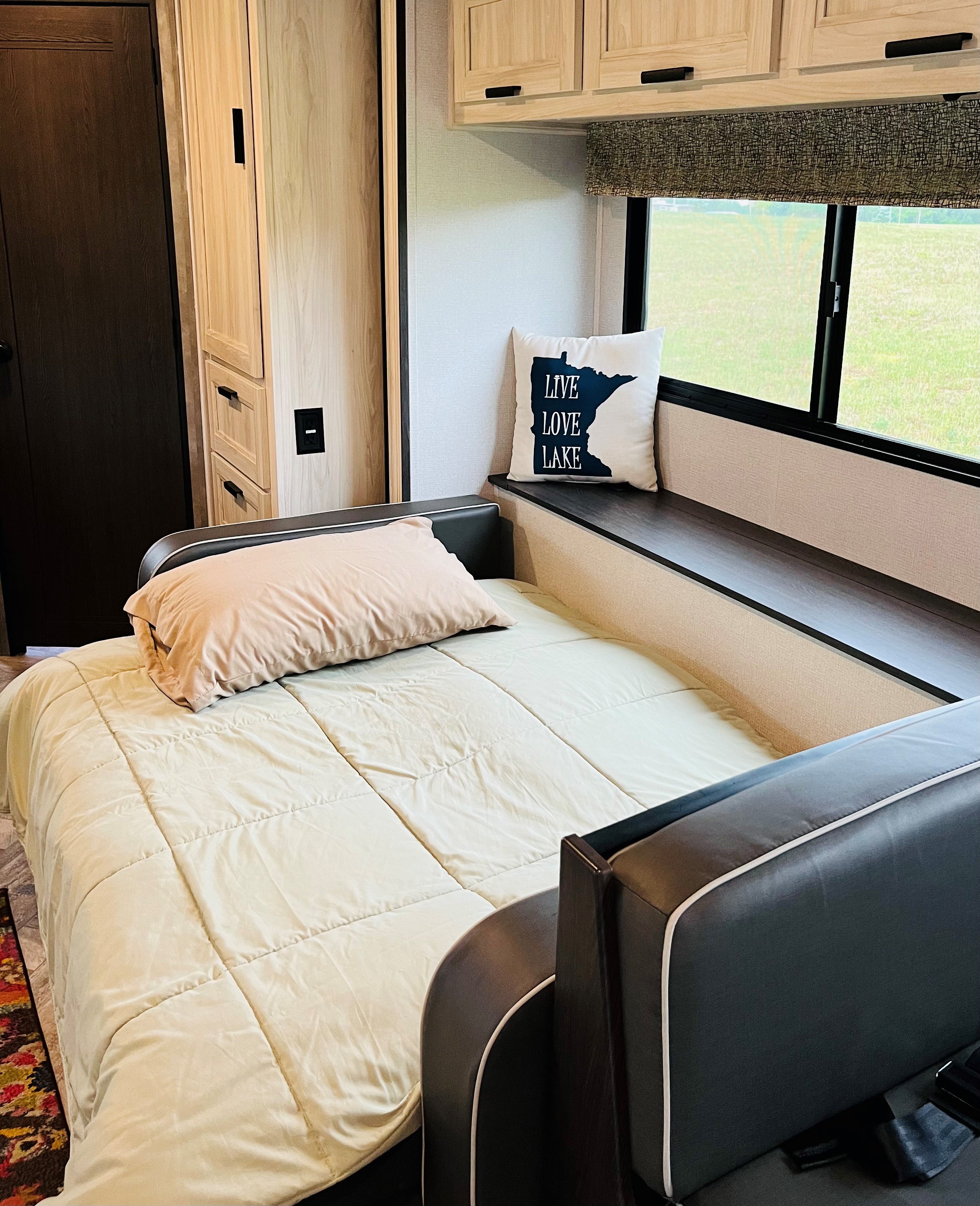 This rv rental offers a comfortable sleeping area with a convertible bed, window seat, and cabinets for storage.. Forester LE 2021