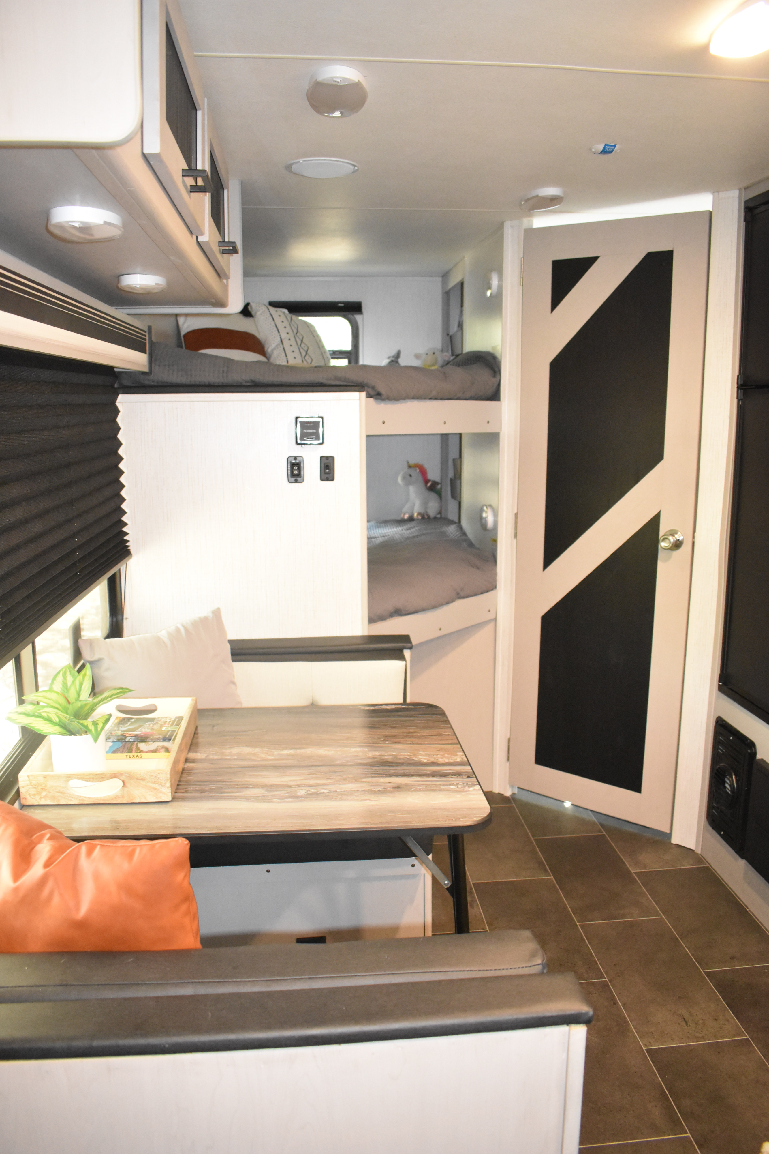 Modern rv rental interior with bright bunk beds, a cozy dining table, and sleek overhead storage, ready for your next adventure.. Heartland RVs Mallard 2022