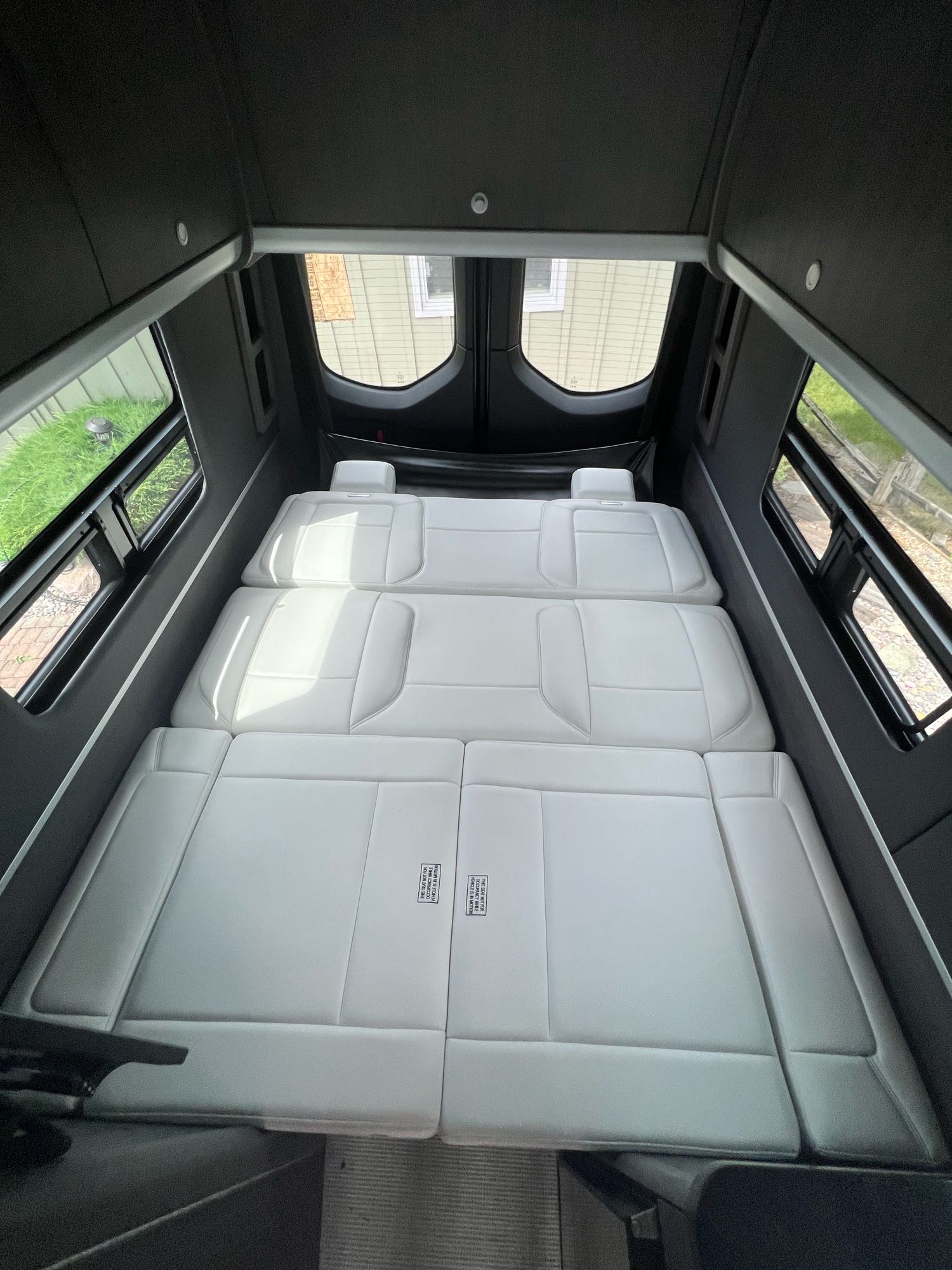 Comfortable RV rental interior featuring a versatile, white cushioned bed/seating area in a modern camper van.. Airstream Interstate 2022