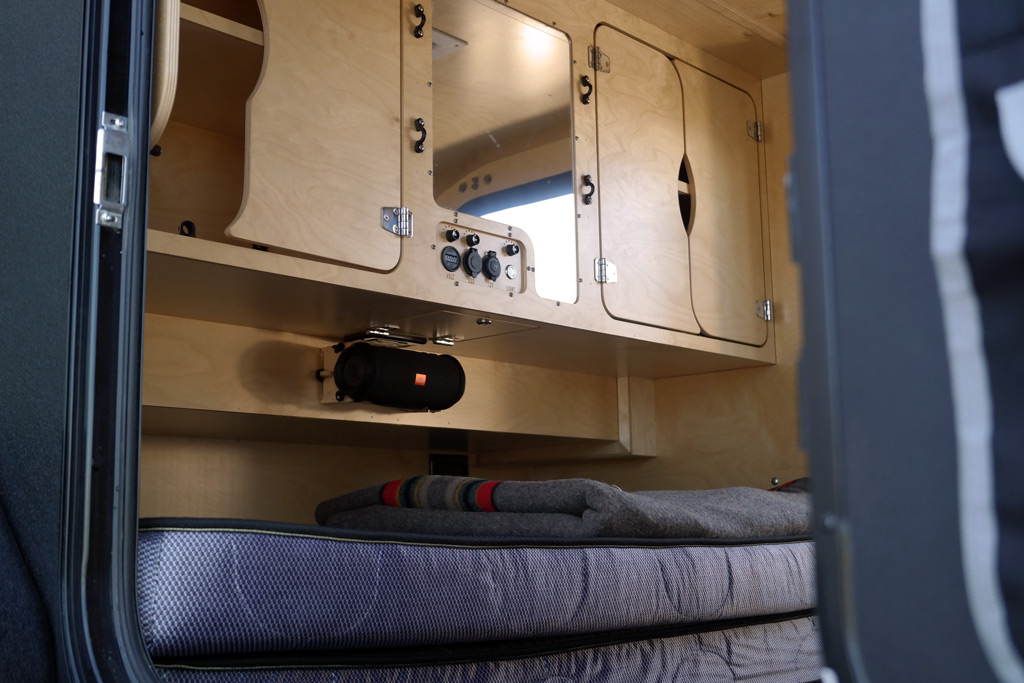 Step inside this cozy RV rental's sleeping area. Features include practical cabinets, power outlets, and a mounted speaker.. Oregon Trail'R TerraDrop ALPHA 2022