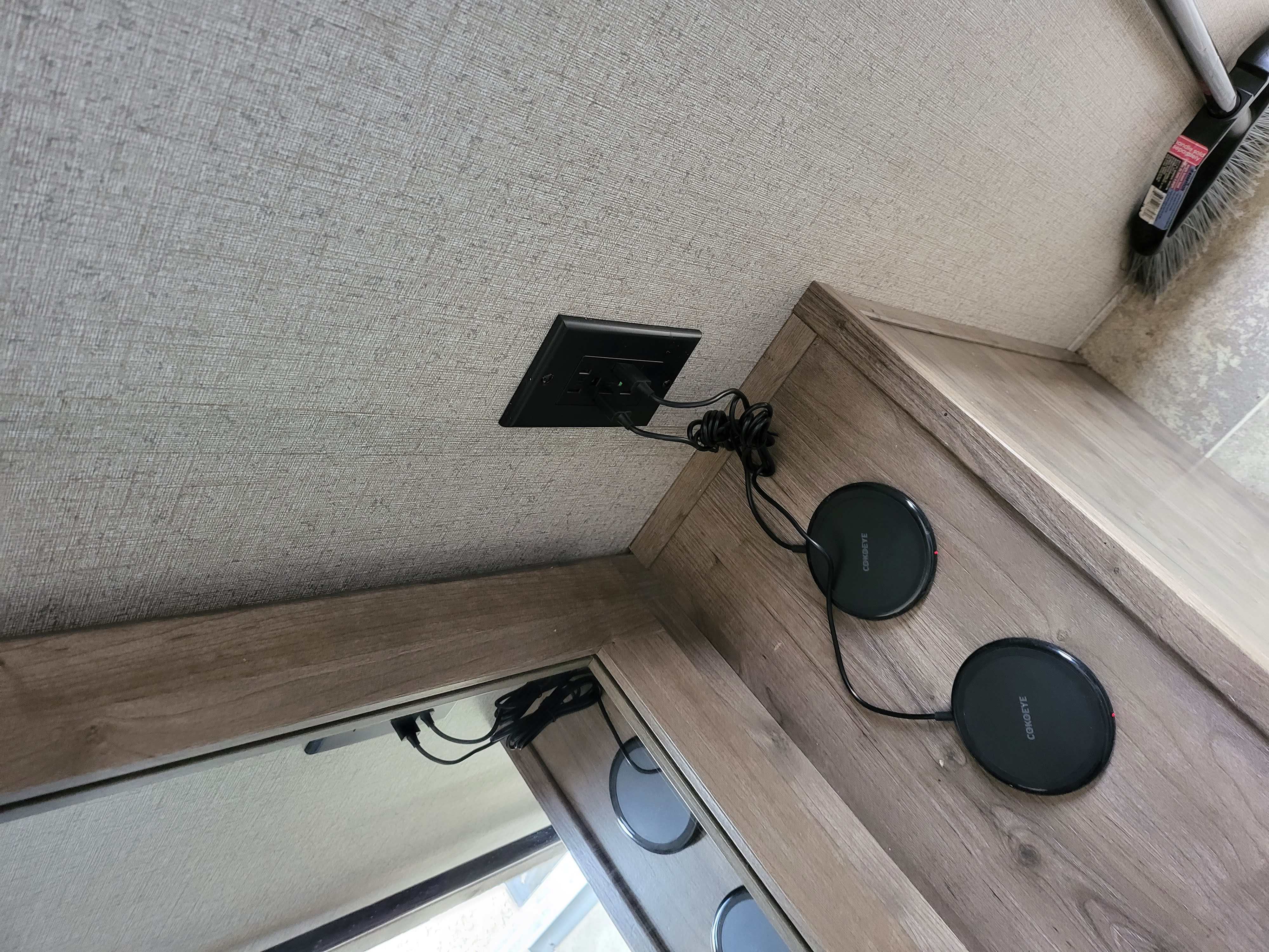 RV rental interior: Wall-mounted USB outlet powers two COKOEYE wireless chargers on a wood cabinet.. Aspen Trail LE 2020