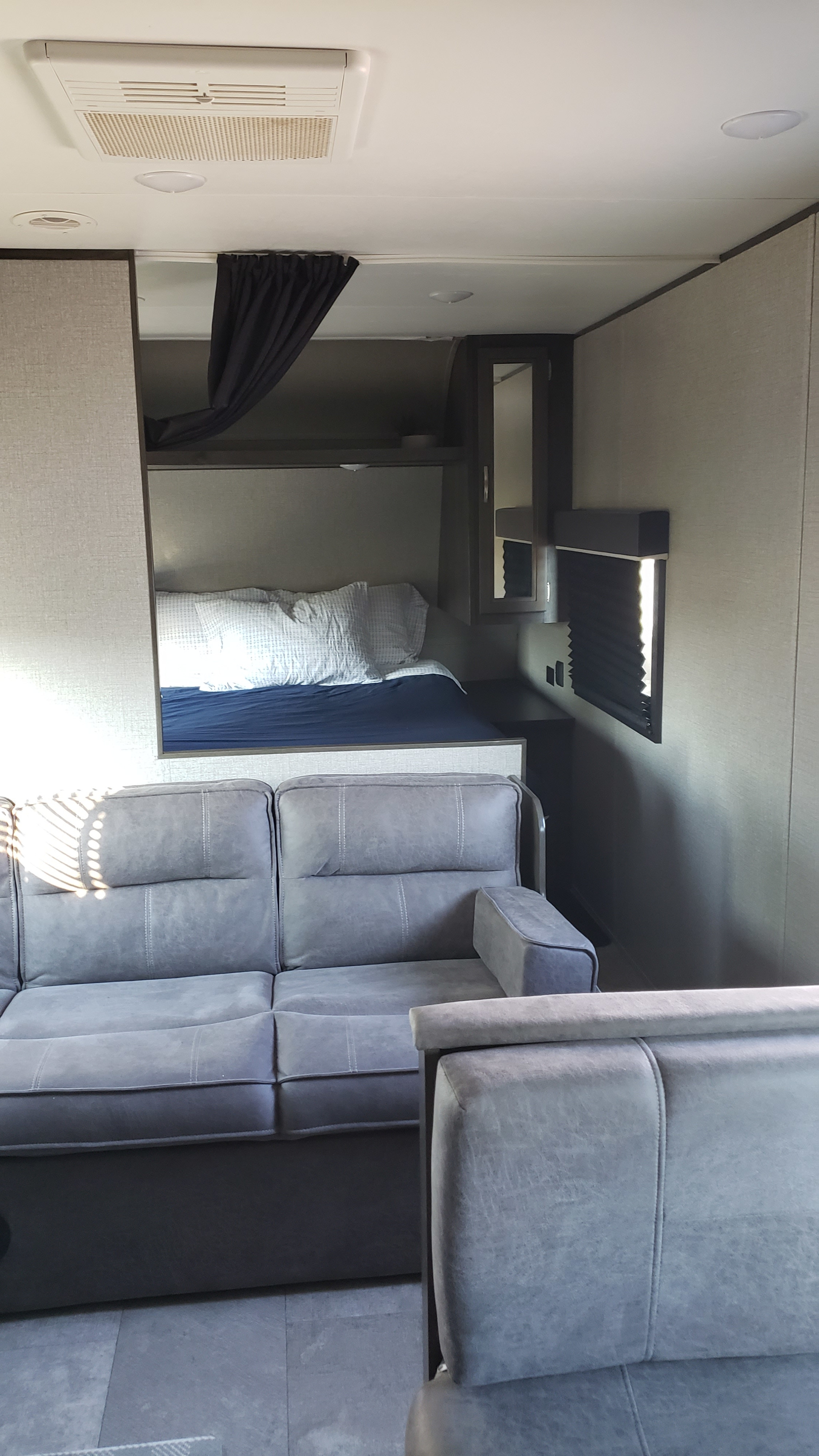 Spacious RV rental interior featuring a comfy gray sofa, bunk bed, and modern lighting. Perfect for travel adventures.. Jayco Jay Flight SLX 2019