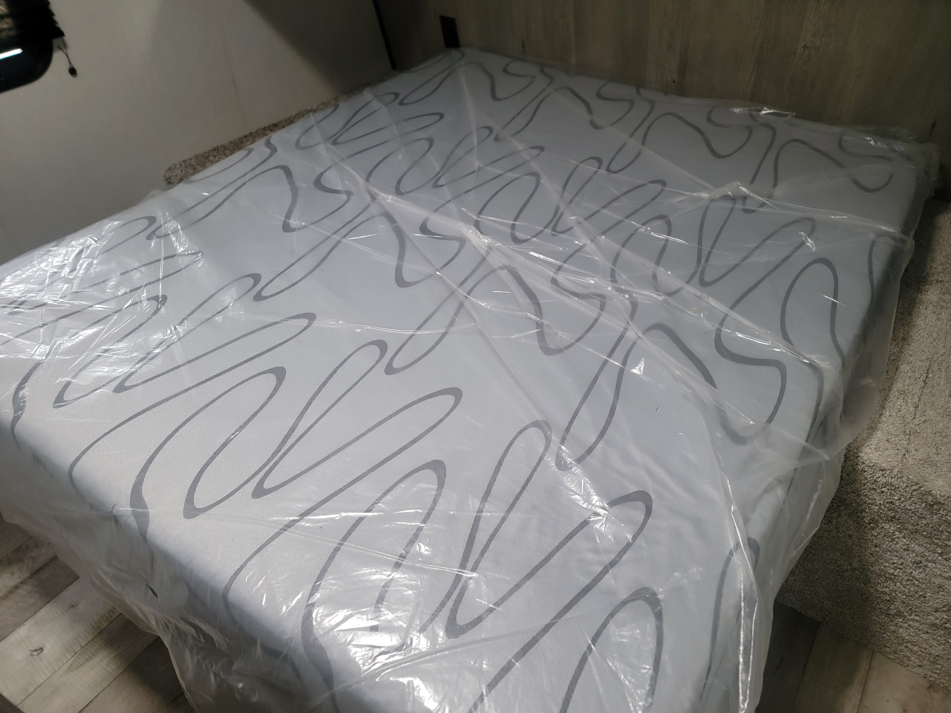 Fresh mattress in protective plastic inside an RV rental, ready for guests.. Keystone RV Springdale 2021