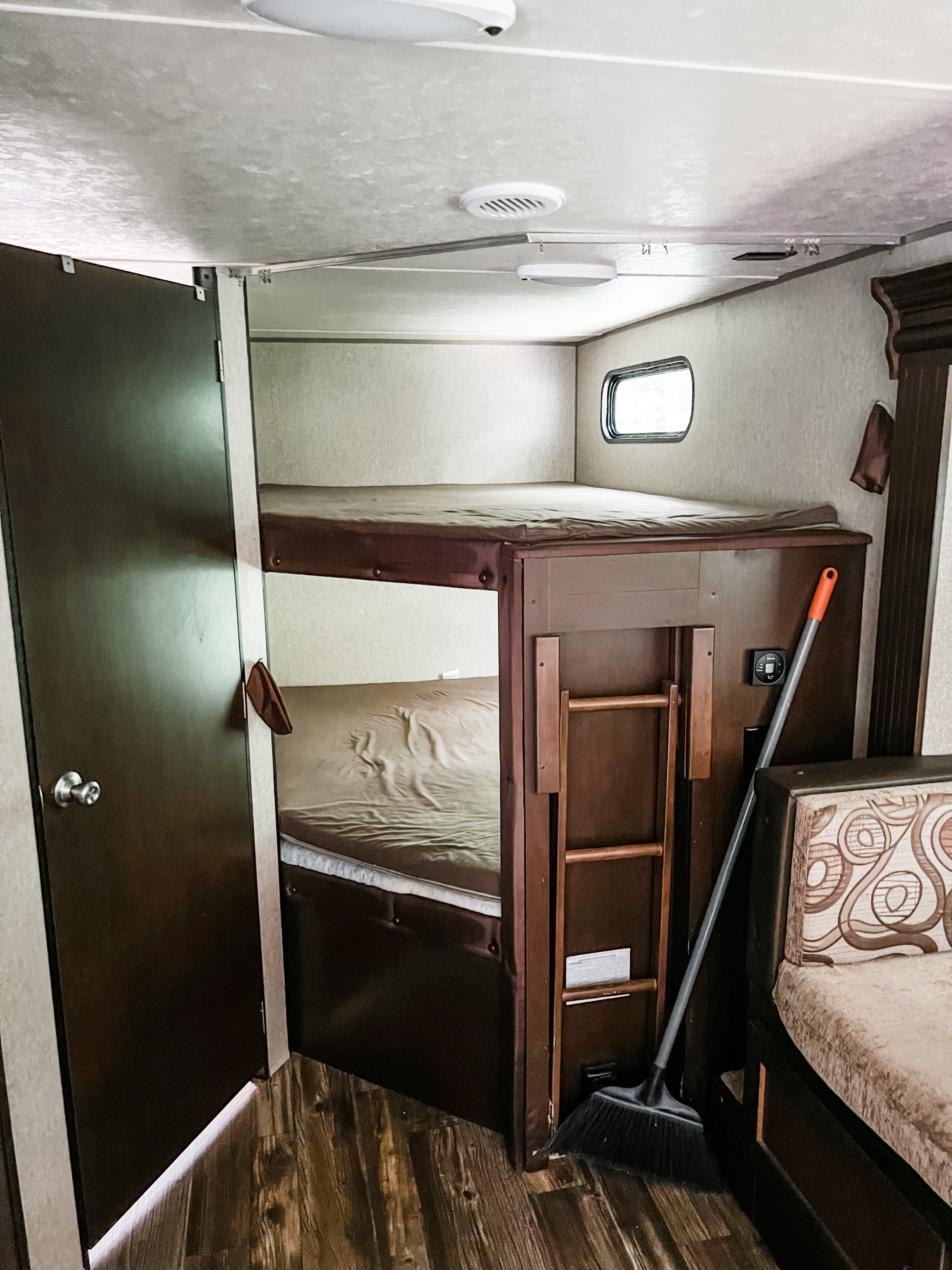 Step inside this RV rental! Features a compact sleeping area with bunk beds, a door, and wood-look flooring.. Forest River Cherokee Grey Wolf 2015