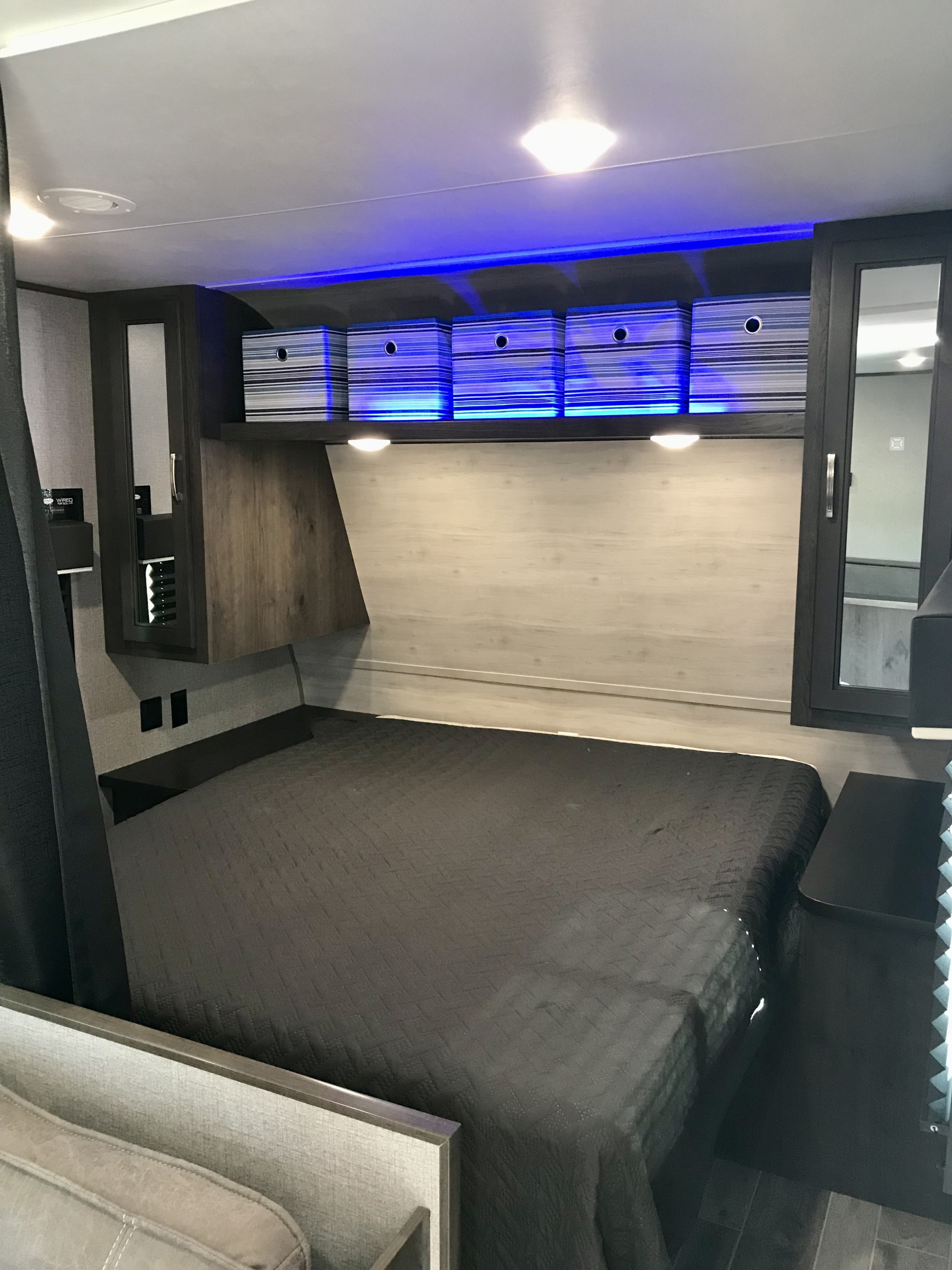 Modern RV rental bedroom featuring blue LED lighting, overhead storage, and a cozy bed for comfortable travels.. Jayco Jay Flight SLX 2021