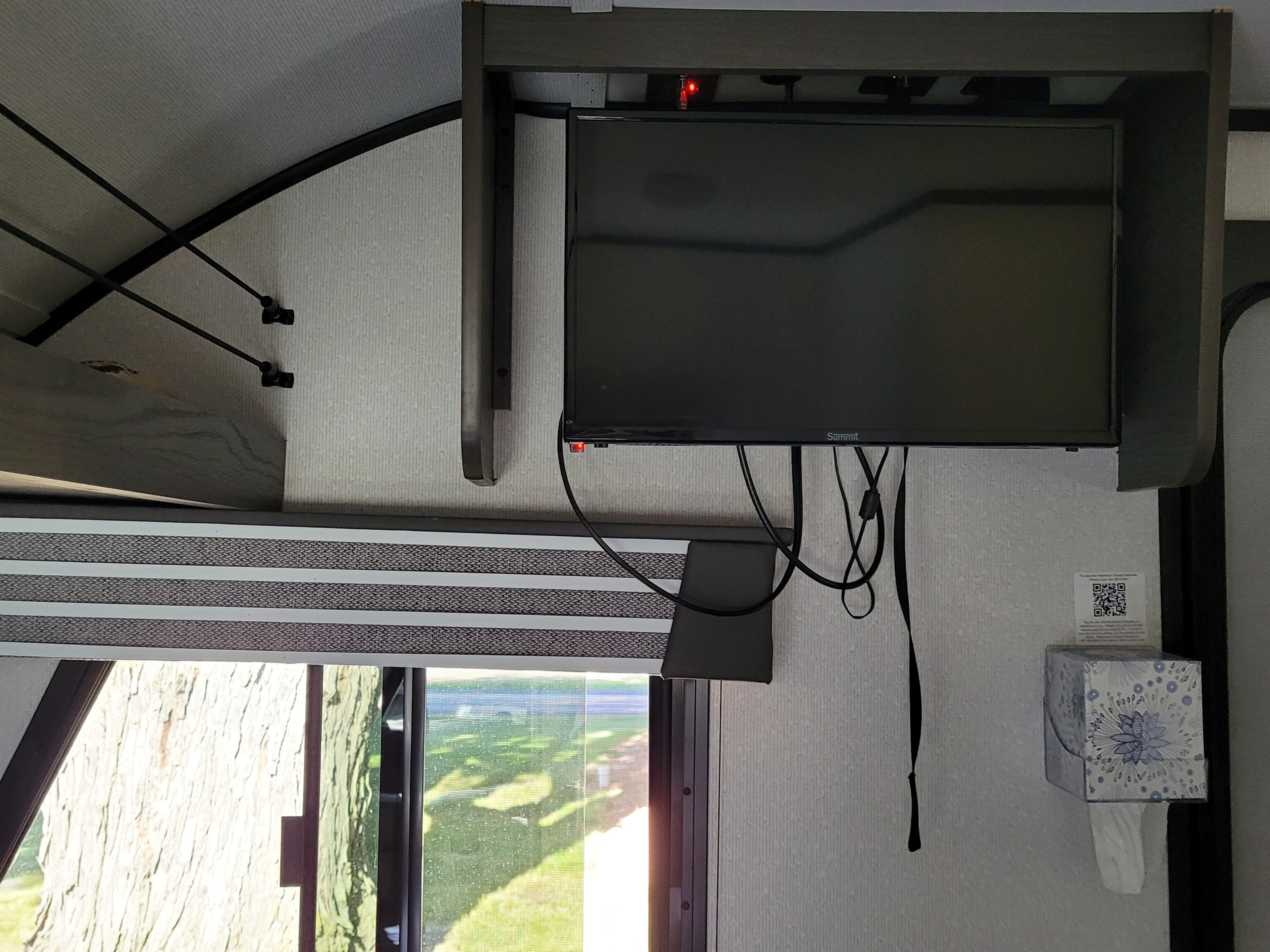 RV rental: Compact interior with overhead TV, a window showing a tree outside, and a wall-mounted tissue dispenser.. Heartland RVs Mallard Pathfinder 2021