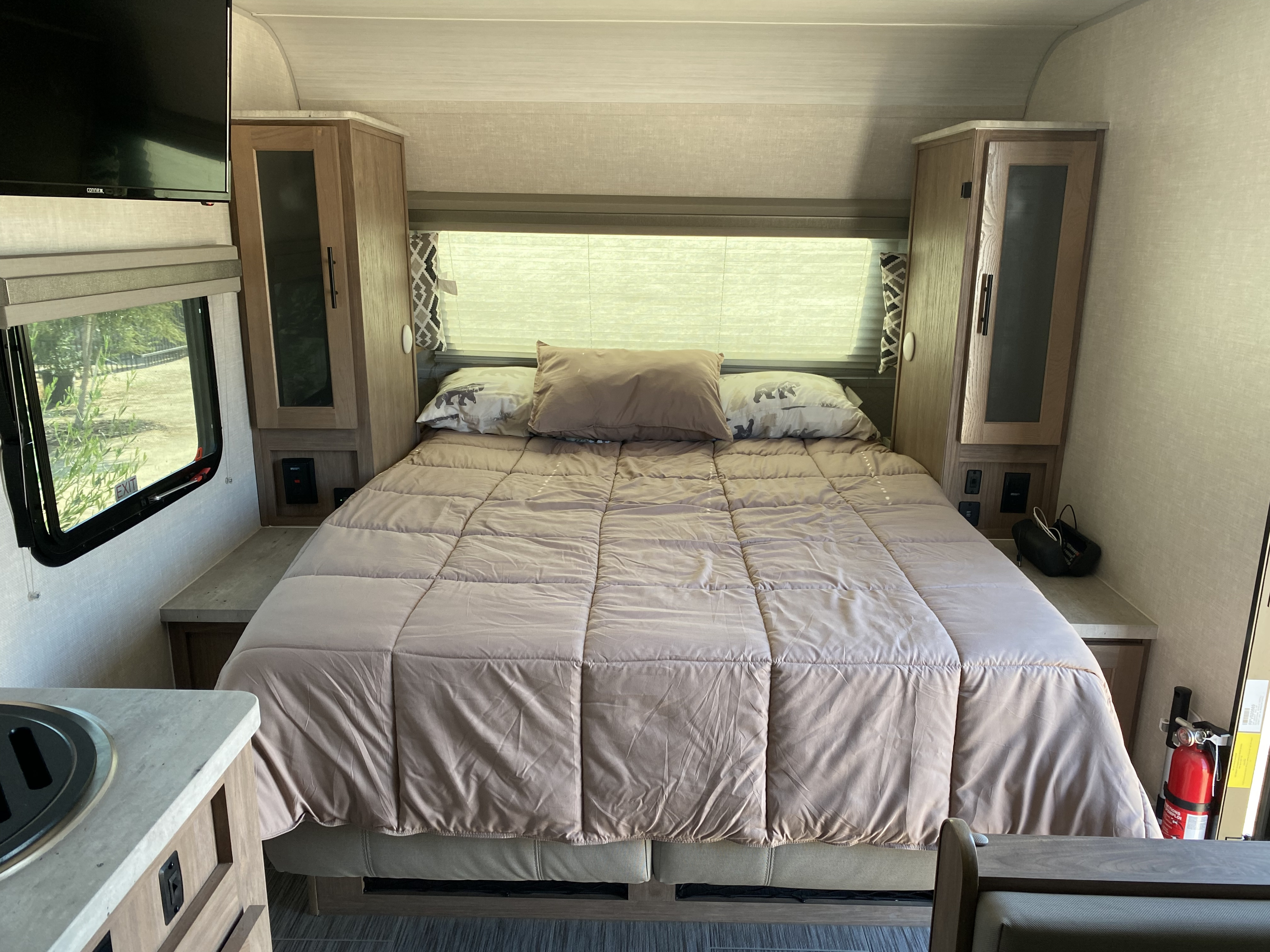 Cozy RV rental bedroom with a comfortable bed, overhead storage, and essential amenities for your travels.. Forest River No Boundaries 19.3 2021