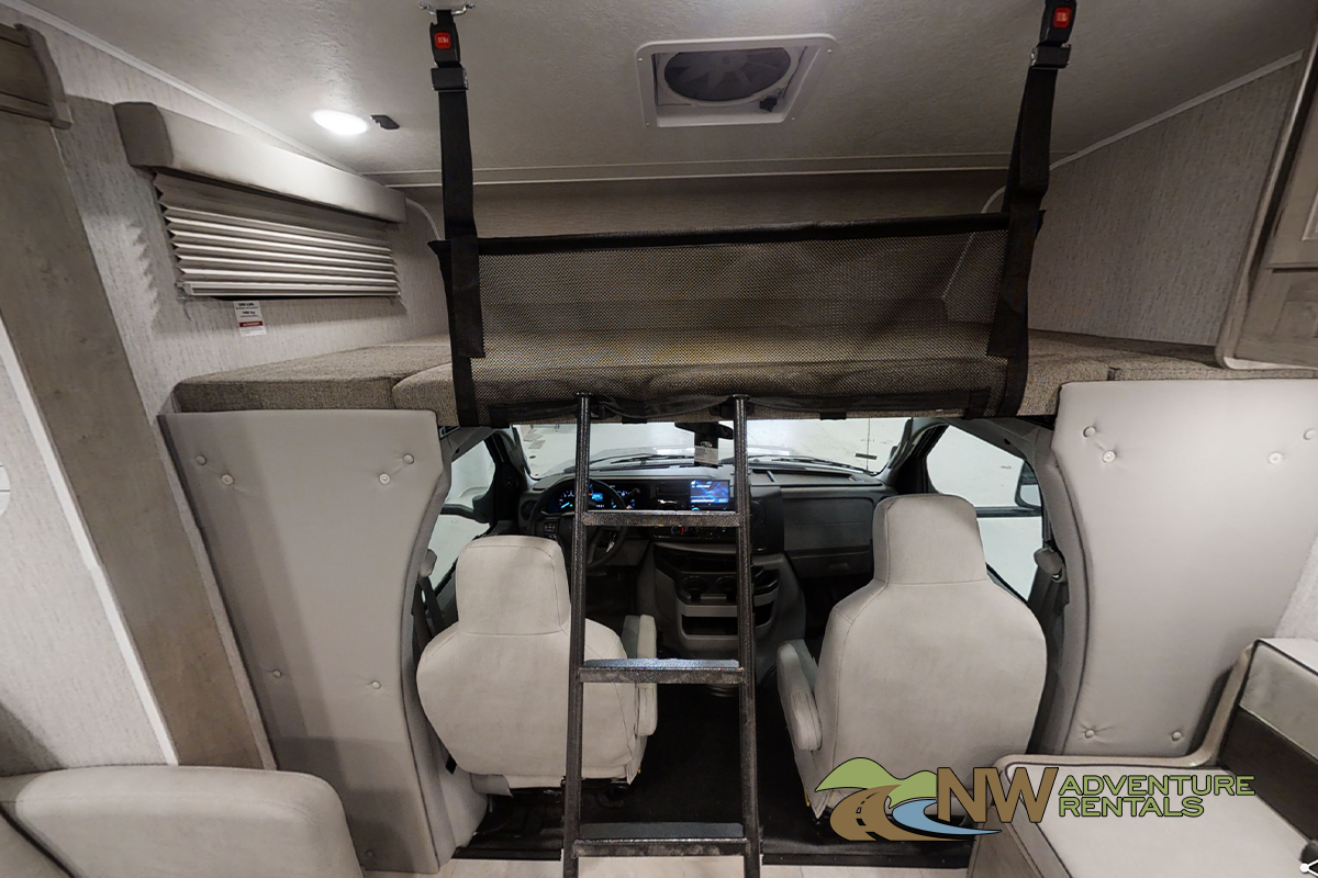 Inside this RV rental: The spacious overhead bunk with safety net and access ladder, overlooking the driver's cabin.. Coachmen Freelander 2021