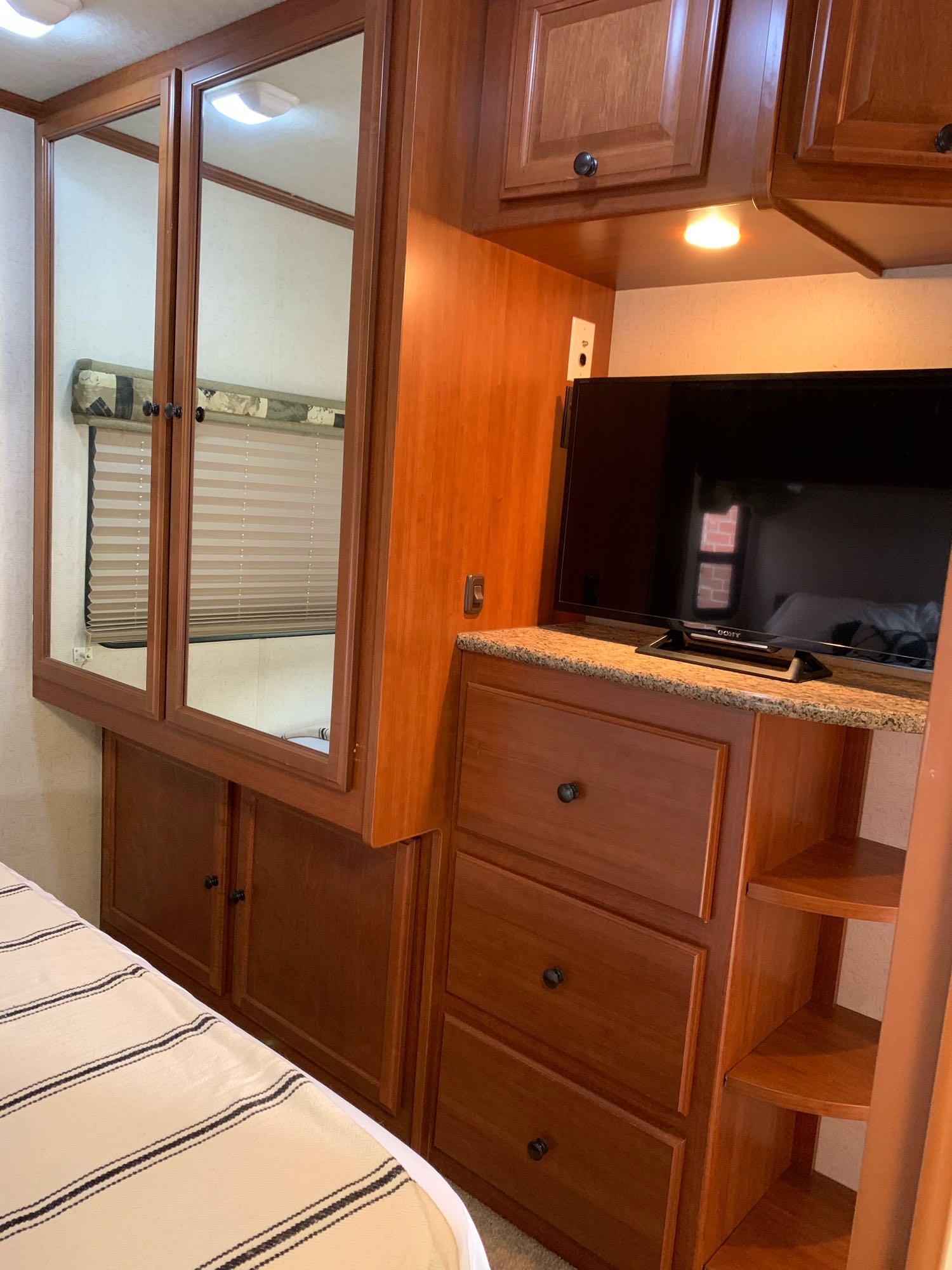 Inside a comfy RV rental: mirrored cabinets, TV, and smart storage maximize space for a relaxing trip.. Jamboree Sport 2010