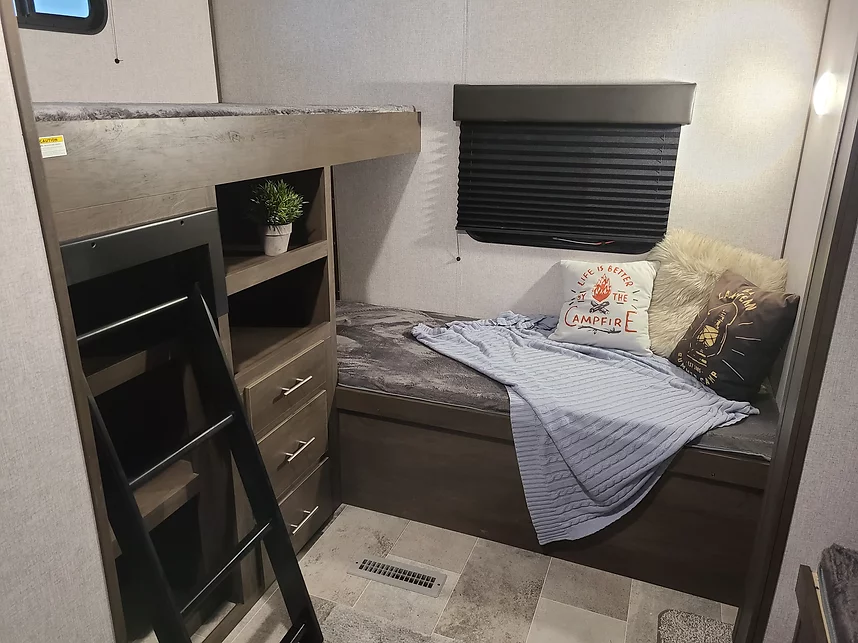 Explore this cozy RV rental bunkhouse area, featuring comfortable bunk beds, built-in storage, and themed decor.. Coleman Lantern 32BHDS 2021