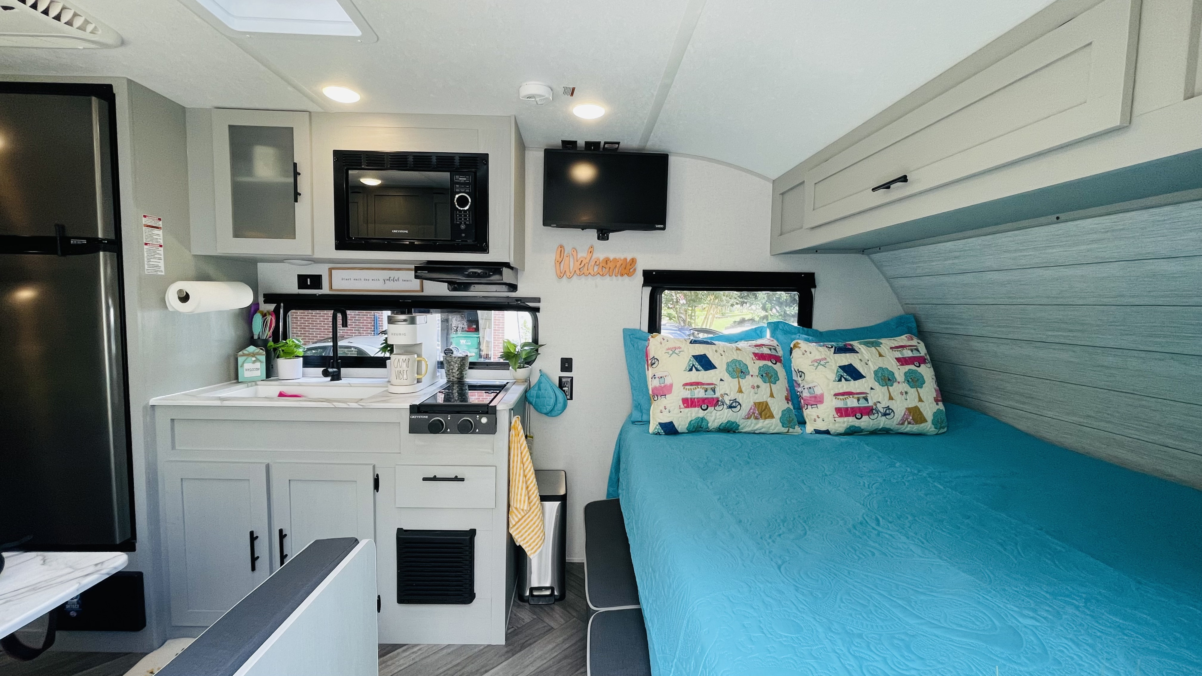 Explore this stylish rv rental: a compact kitchen, microwave, fridge, and cozy bed for your road trip comfort.. Forest River Salem FSX 2022