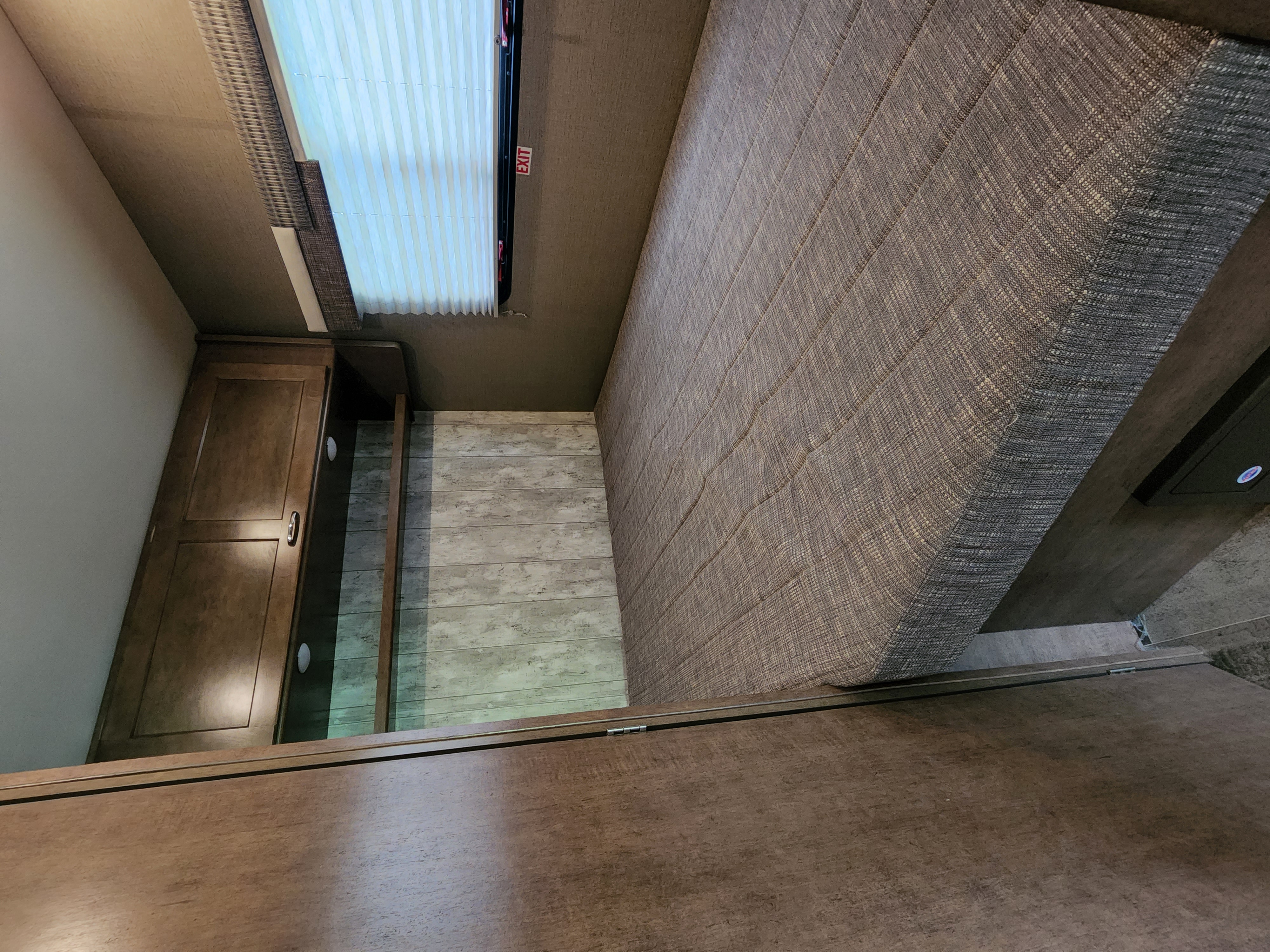 Cozy RV rental bedroom features a comfy bed, window with blinds, and storage cabinets.. Winnebago Outlook 2019