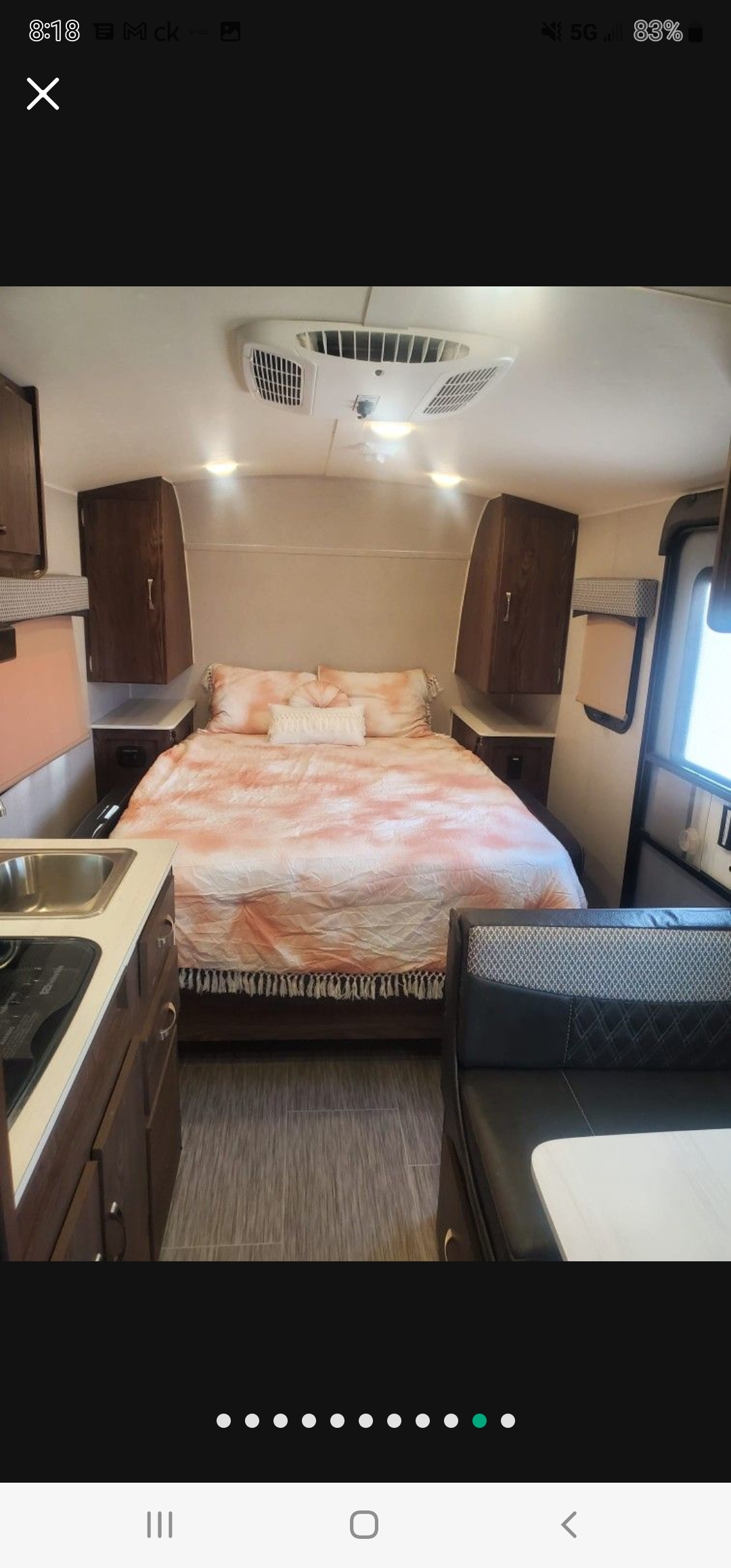 Interior of an **rv rental**: a cozy bedroom with pink bedding, compact kitchen, and dinette area visible. Features overhead AC.. Forest River Rockwood Geo Pro 2018