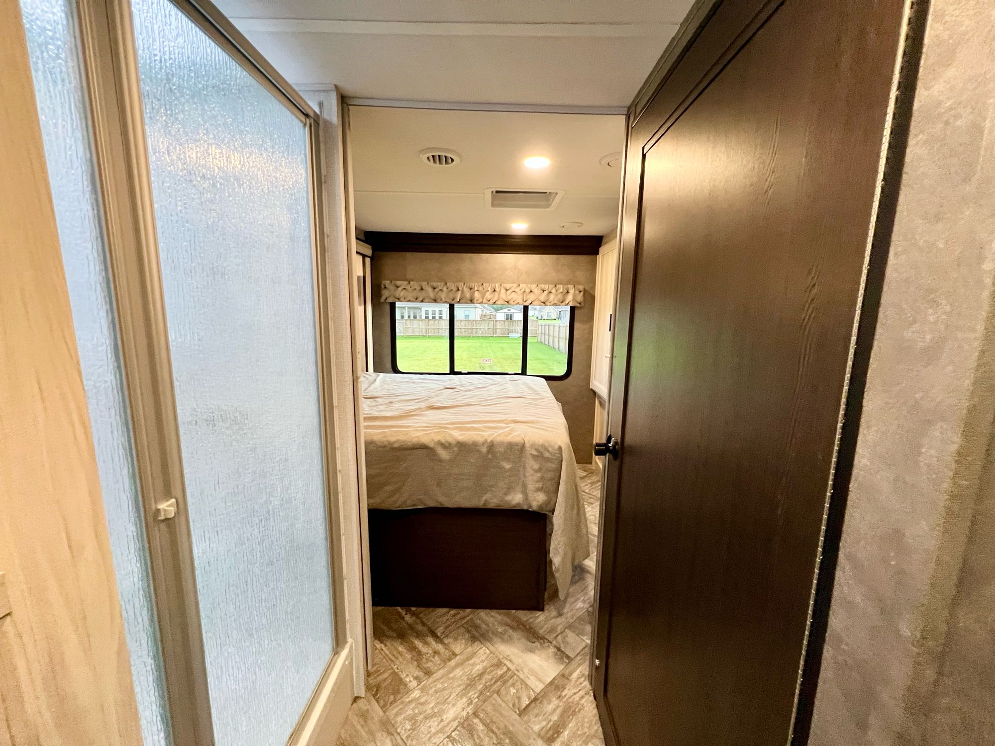 Discover your next RV rental: a modern interior with a private bedroom and frosted glass shower visible.. Forest River Sunseeker Classic 2021