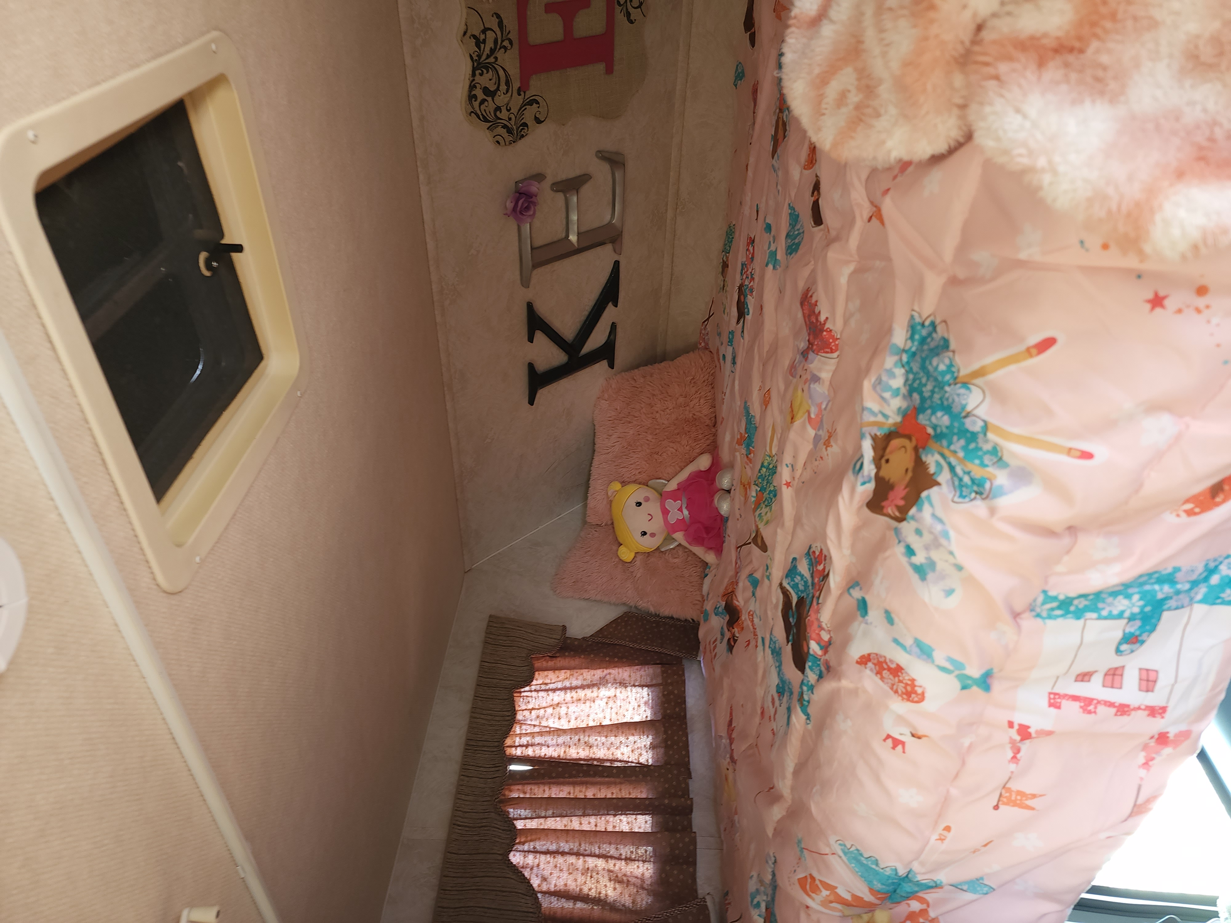 Pink-themed kids' sleeping area in an RV rental, complete with a doll and fun comforter.. Triple E Senator 1998