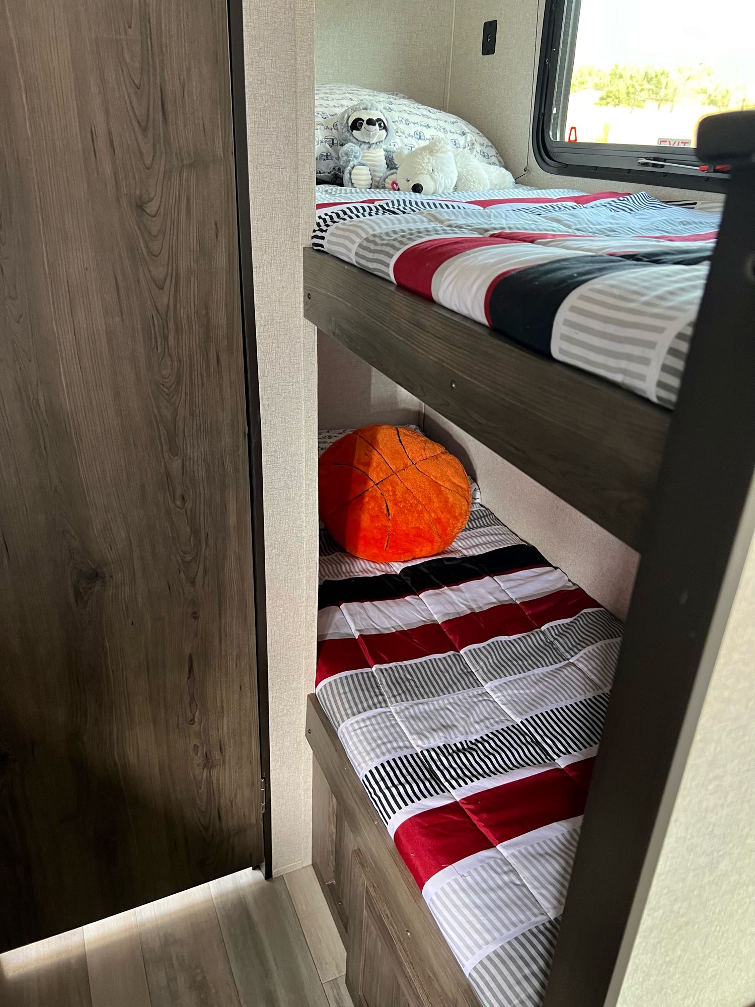 Cozy bunk beds in an RV rental, perfect for family travel. Features striped bedding, window view, and fun pillows.. Clipper Clipper Trailer 2021