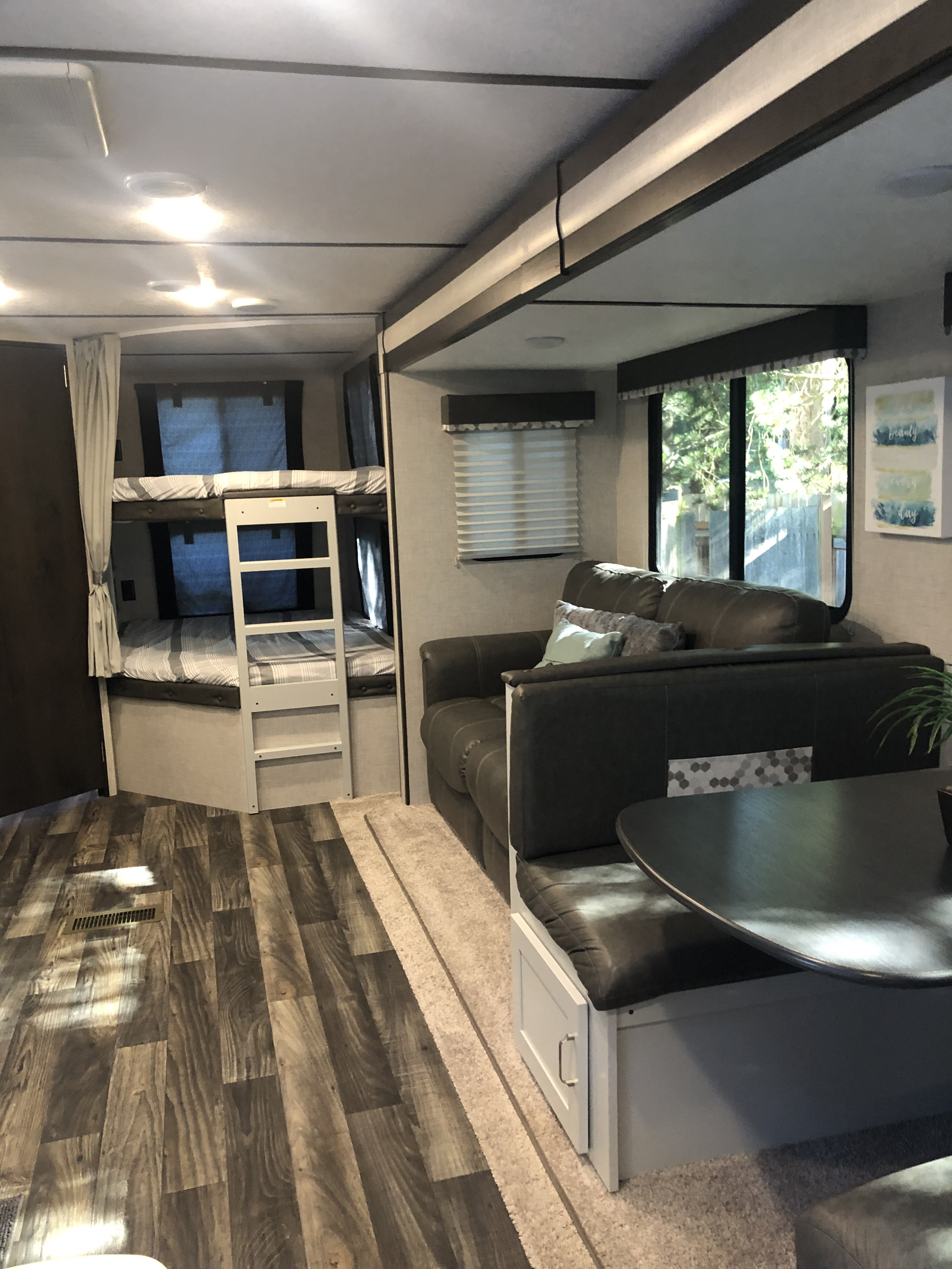 Spacious RV rental interior with bunk beds, a cozy dinette, and wood-look flooring.. Keystone RV Bullet Ultra Lite 2020