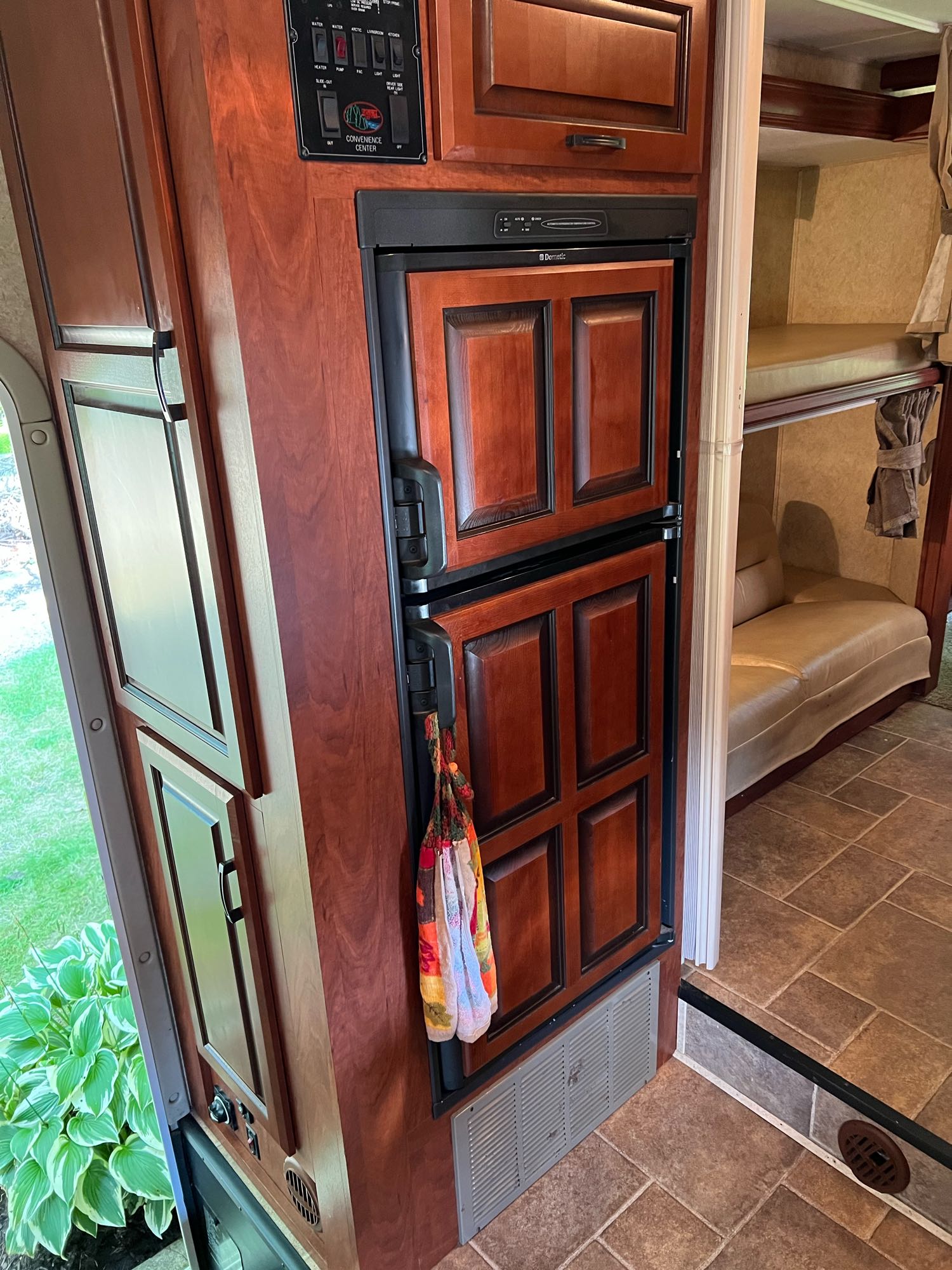 An RV rental's well-appointed interior features a Dometic fridge, wood cabinetry, control panel, and bunk beds.. Forest River Sunseeker 2013