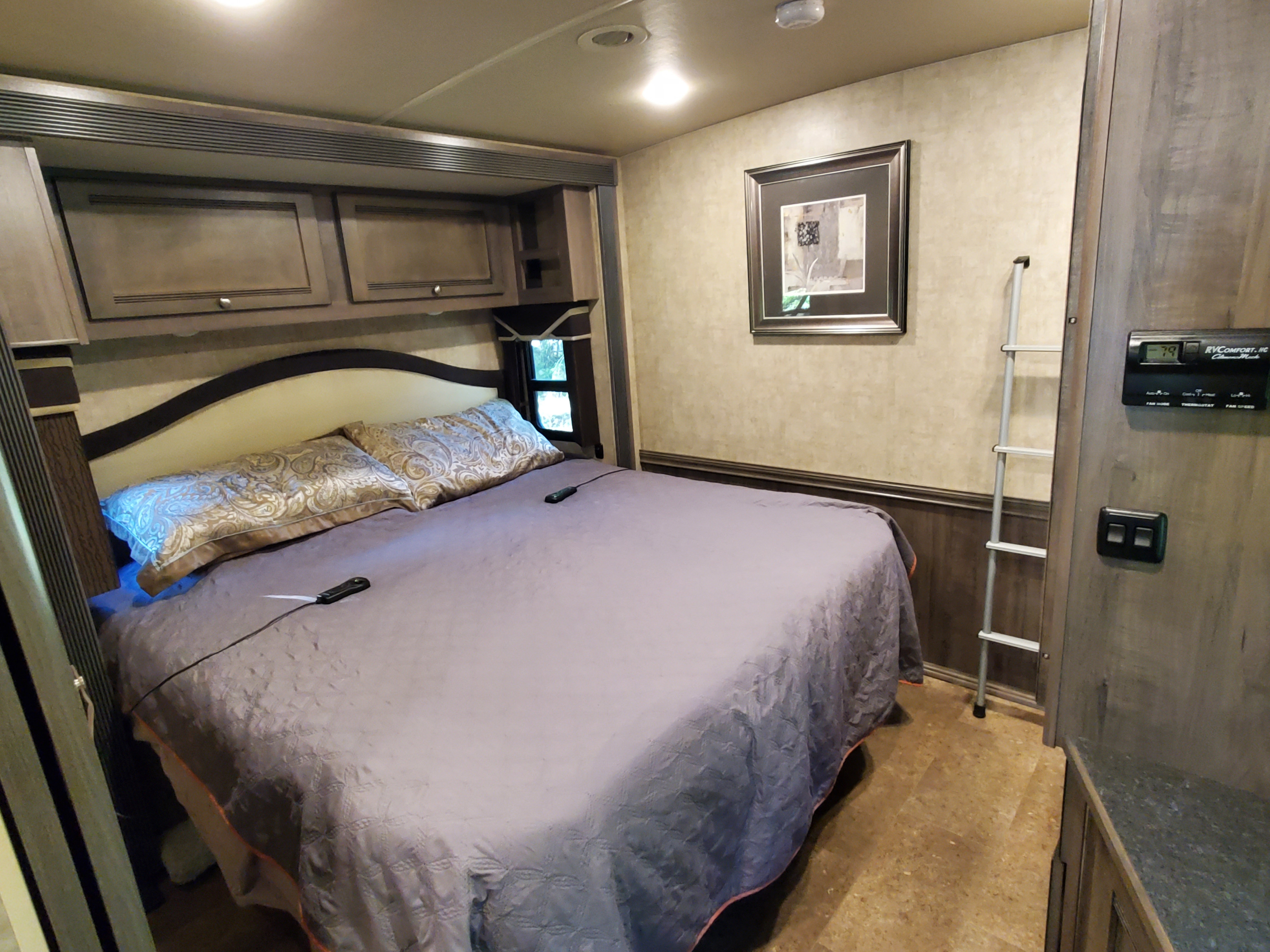 This RV rental bedroom features a large bed, overhead cabinets, climate control, and a ladder, perfect for your travels.. Itasca Sunova 2016
