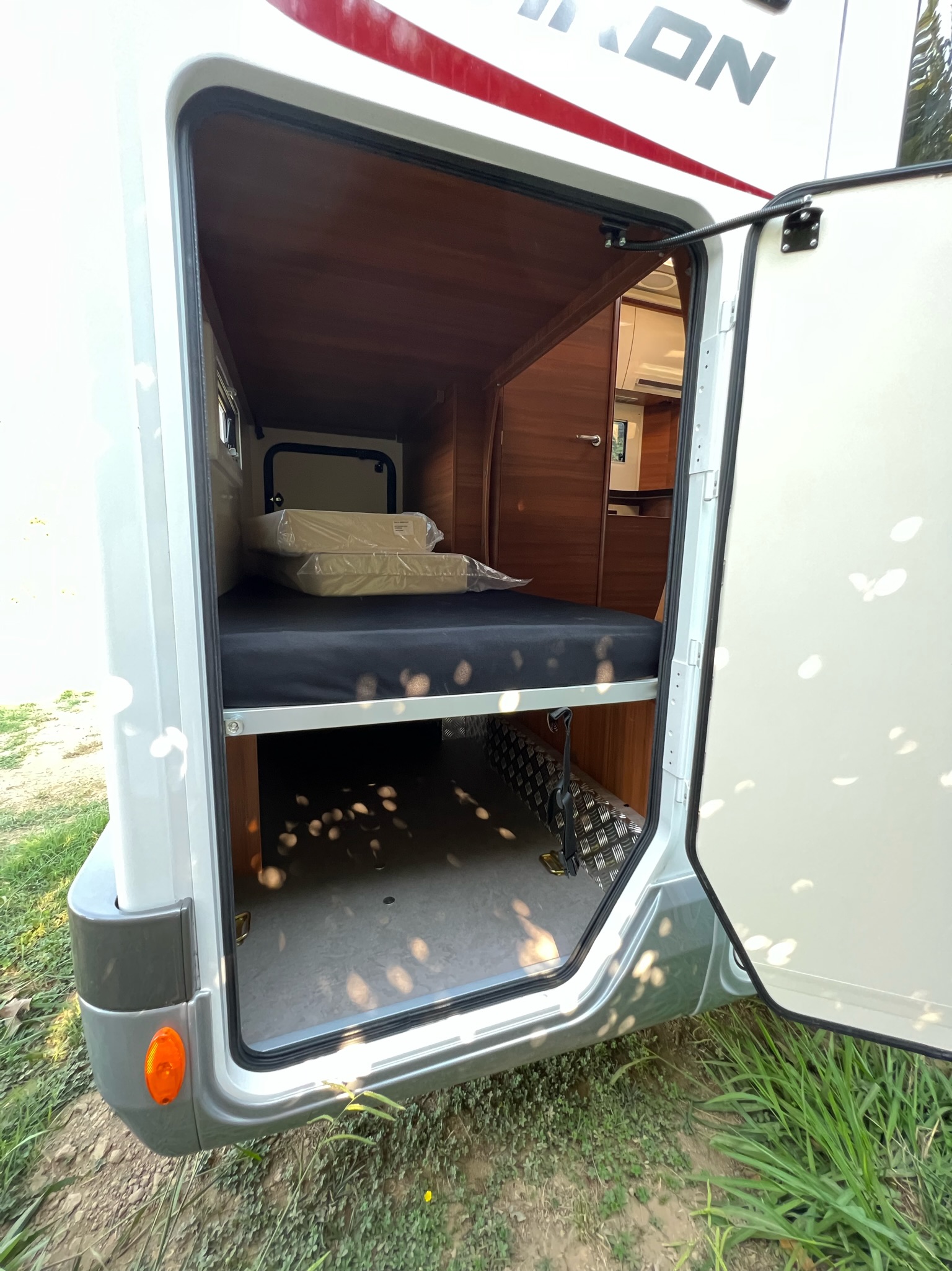 This RV rental features a versatile rear compartment with a bunk bed above ample storage, ideal for road trips.. Elnagh Baron 22 2022