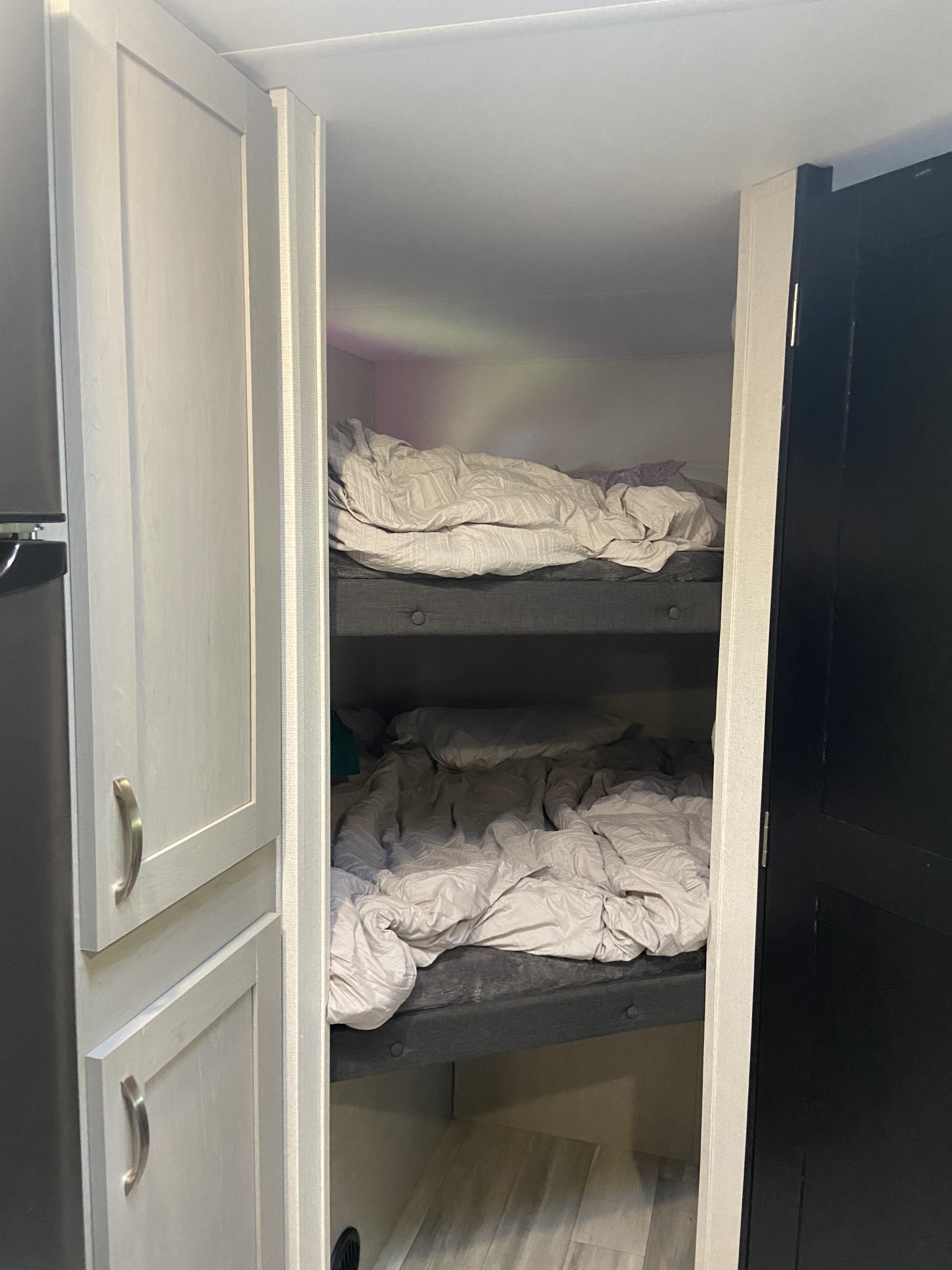 Inside an RV rental: Compact bunk beds with bedding, offering a cozy sleeping area for travelers.. Forest River Tracer LE 2022