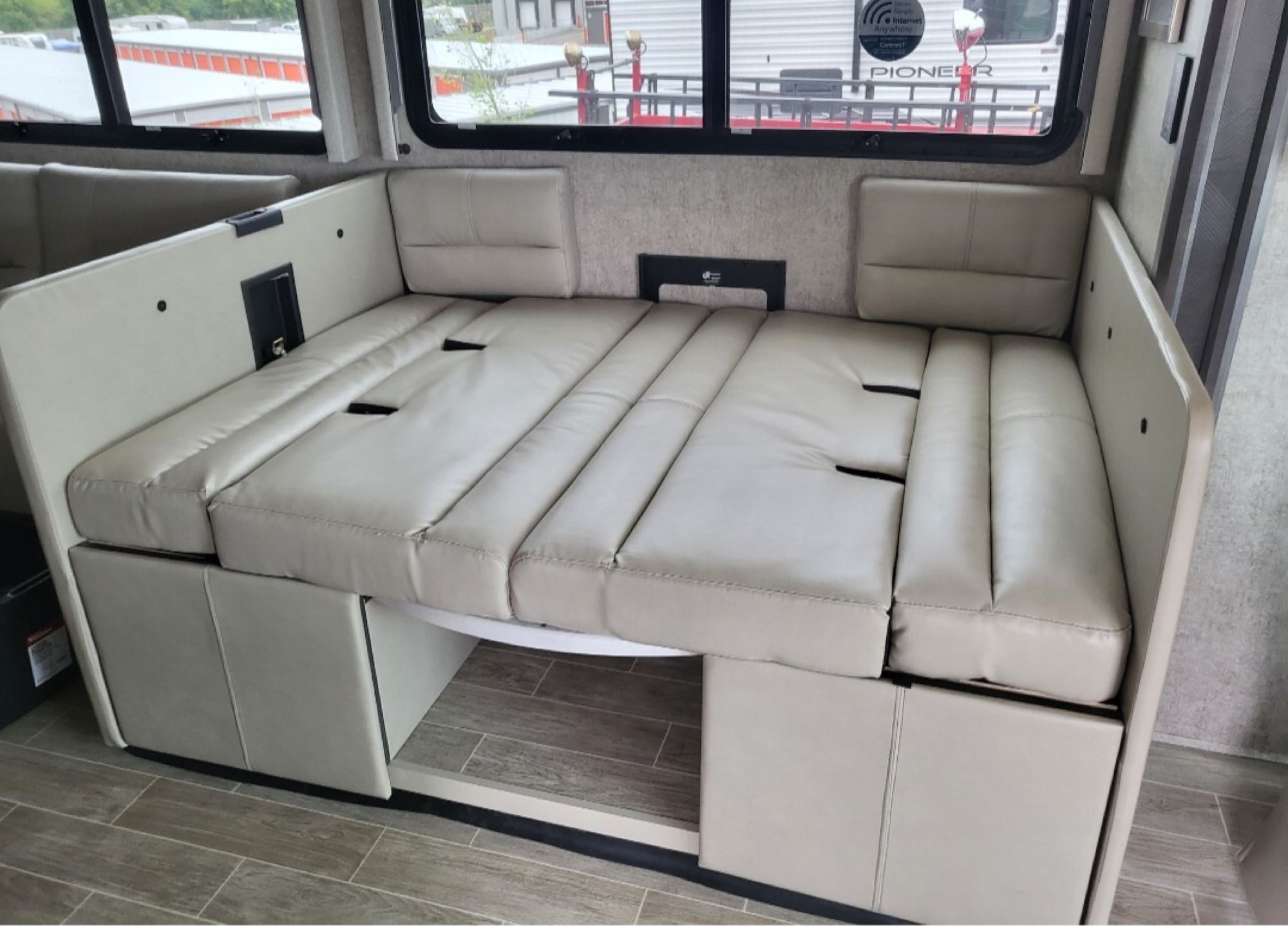 Cream-toned RV rental dinette transforms into a bed, providing comfortable sleeping for your journey.. Thor Miramar 2022