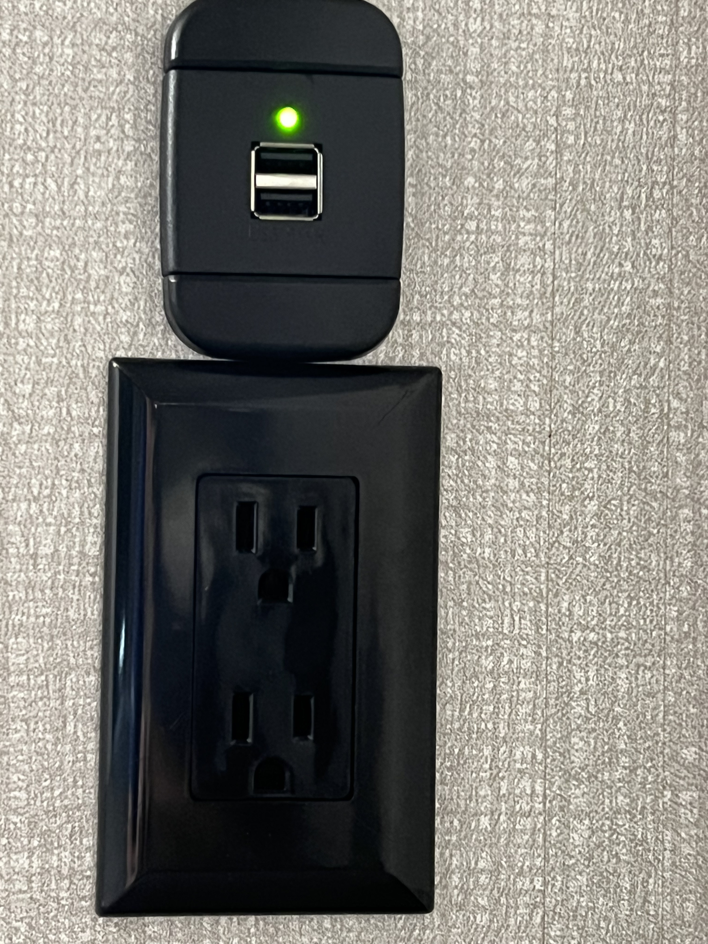 RV rental essential: A black USB charging port with a green LED and a standard power outlet are visible against a textured wall, ready for devices.. Dream 290DBS 2022