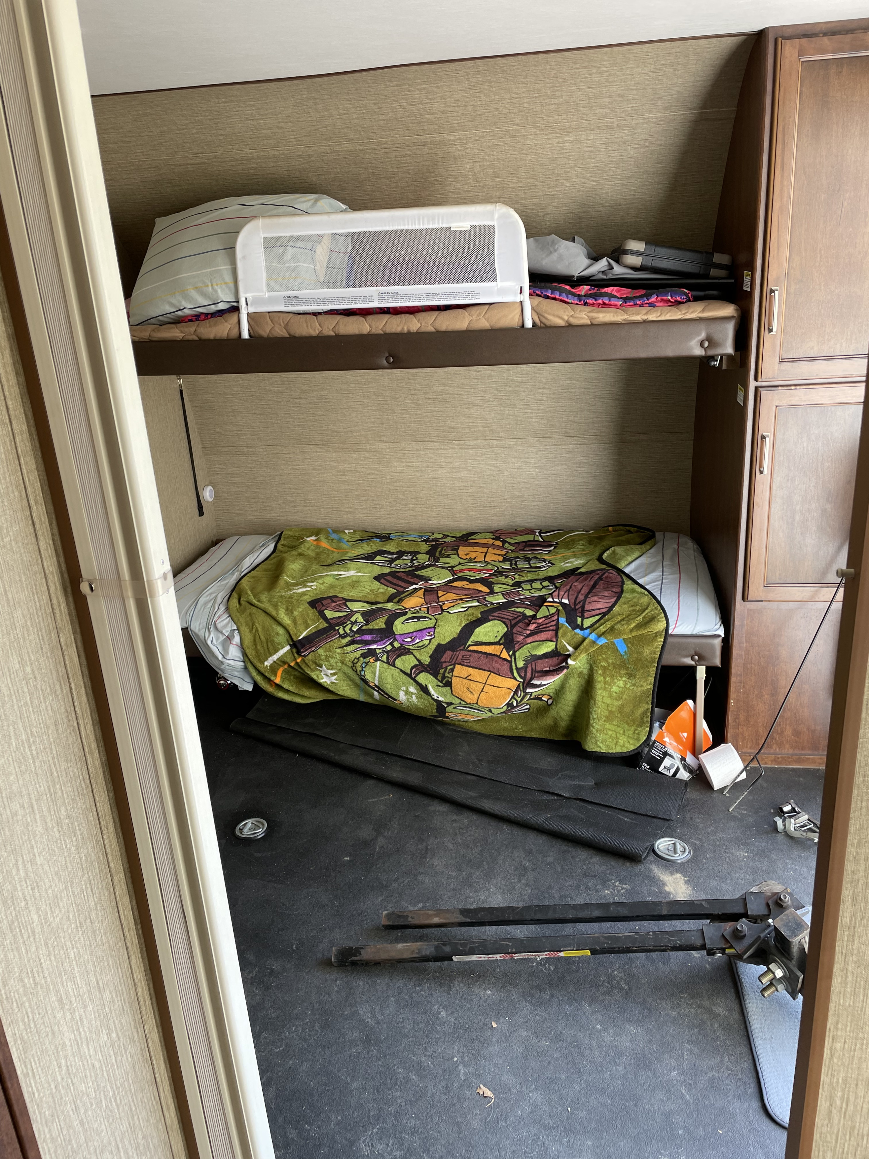 RV rental interior features bunk beds: upper with safety rail, lower with TMNT blanket. Practical camper sleeping area.. Keystone Outback 2018