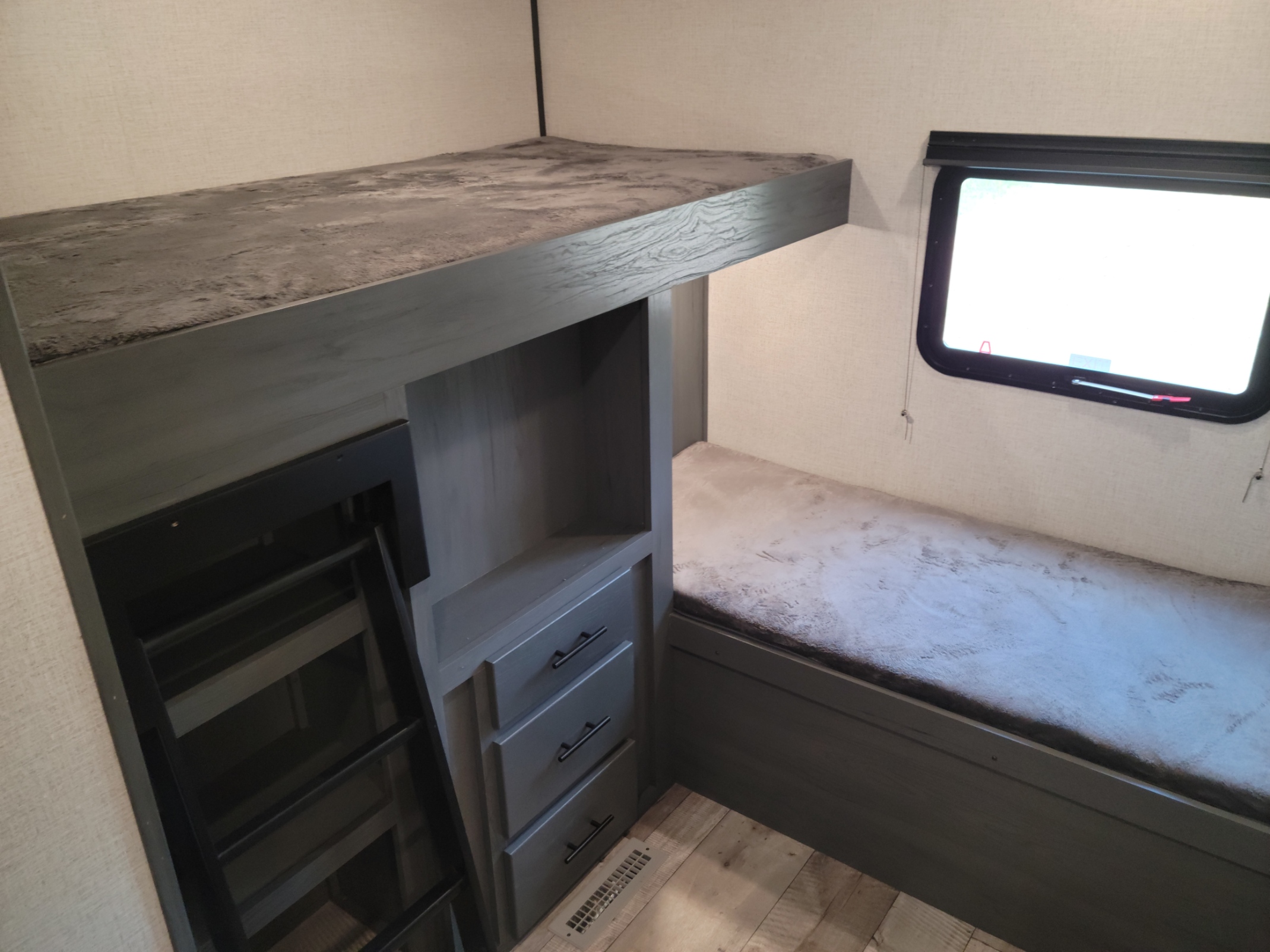 Explore this RV rental's clever bunk bed setup: upper bunk, ladder, lower bed, storage drawers, and window.. Dutchmen Aspen Trail 2021