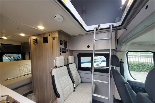Interior of a compact RV rental, showcasing a bunk bed ladder, comfortable seating, and functional living space for travel.. Winnebago Solis 2022