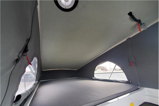 Explore your RV rental's pop-top sleeping area, featuring a comfortable bed, soft walls, and arched windows.. Winnebago Solis 2022