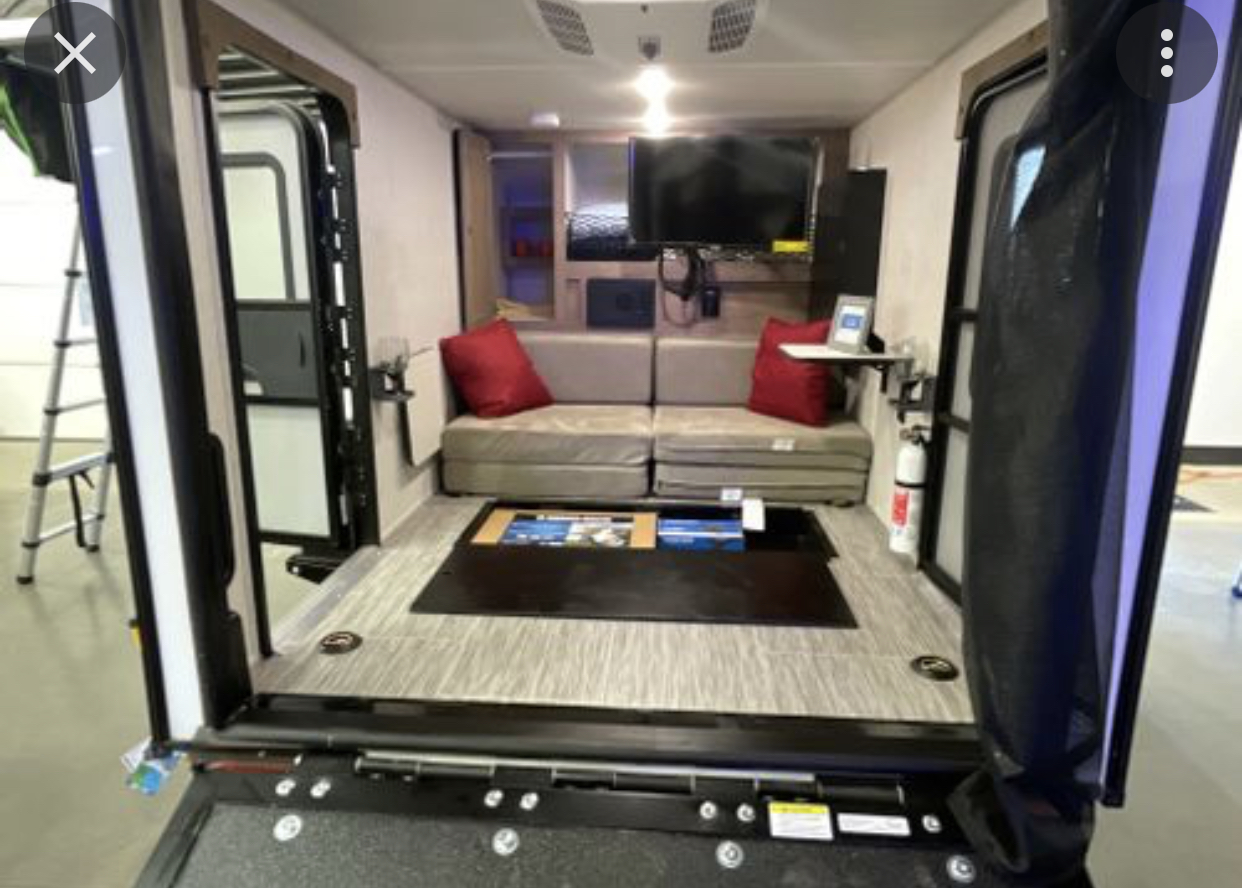 RV rental interior: versatile living space with convertible sofa, entertainment, and rear ramp access for gear.. Forest River NOBO 10.6 2022