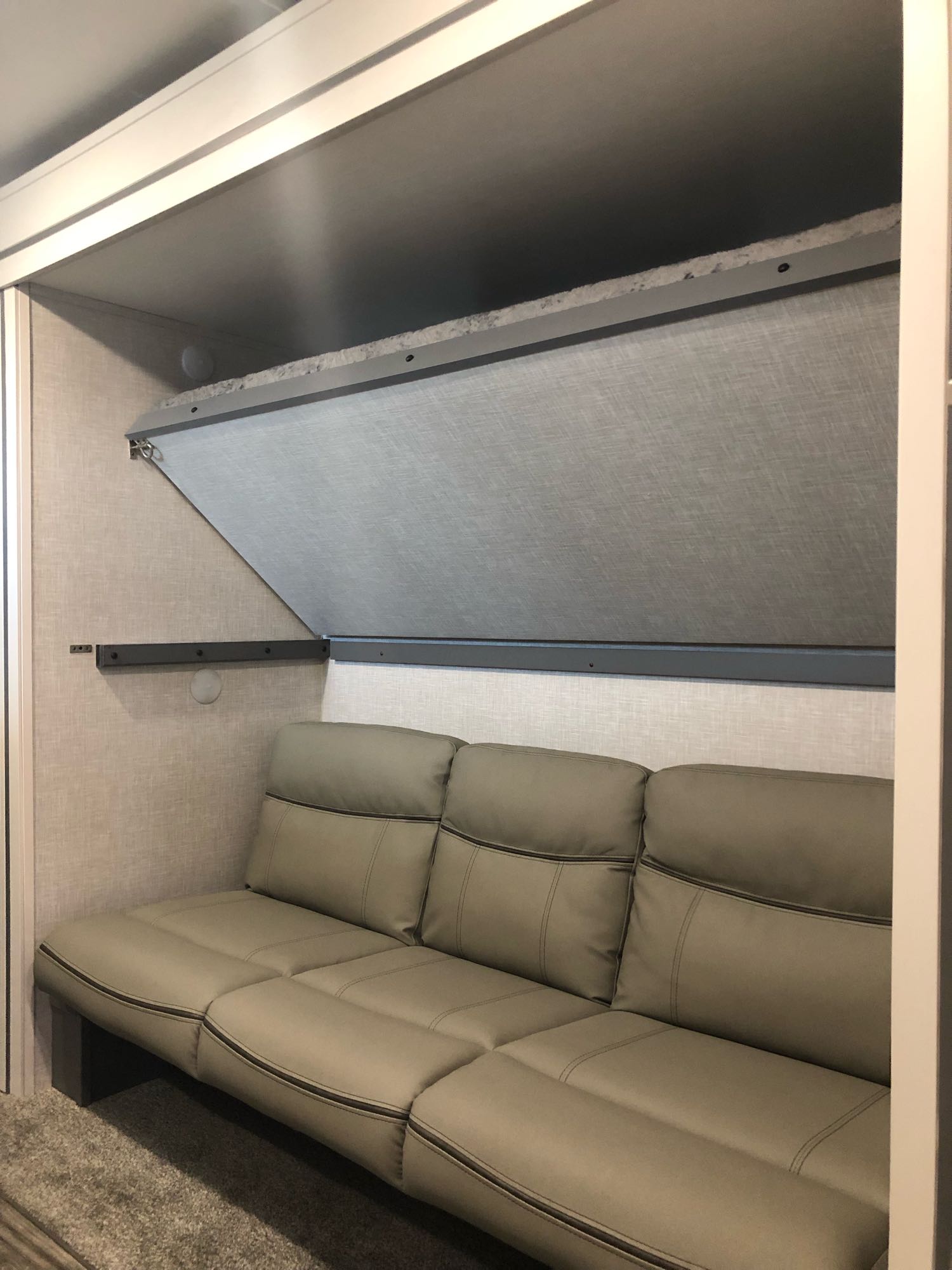 RV rental interior with a comfy sofa and a space-saving, fold-down bunk bed above, ideal for flexible sleeping.. Crossroads RV Volante 2022