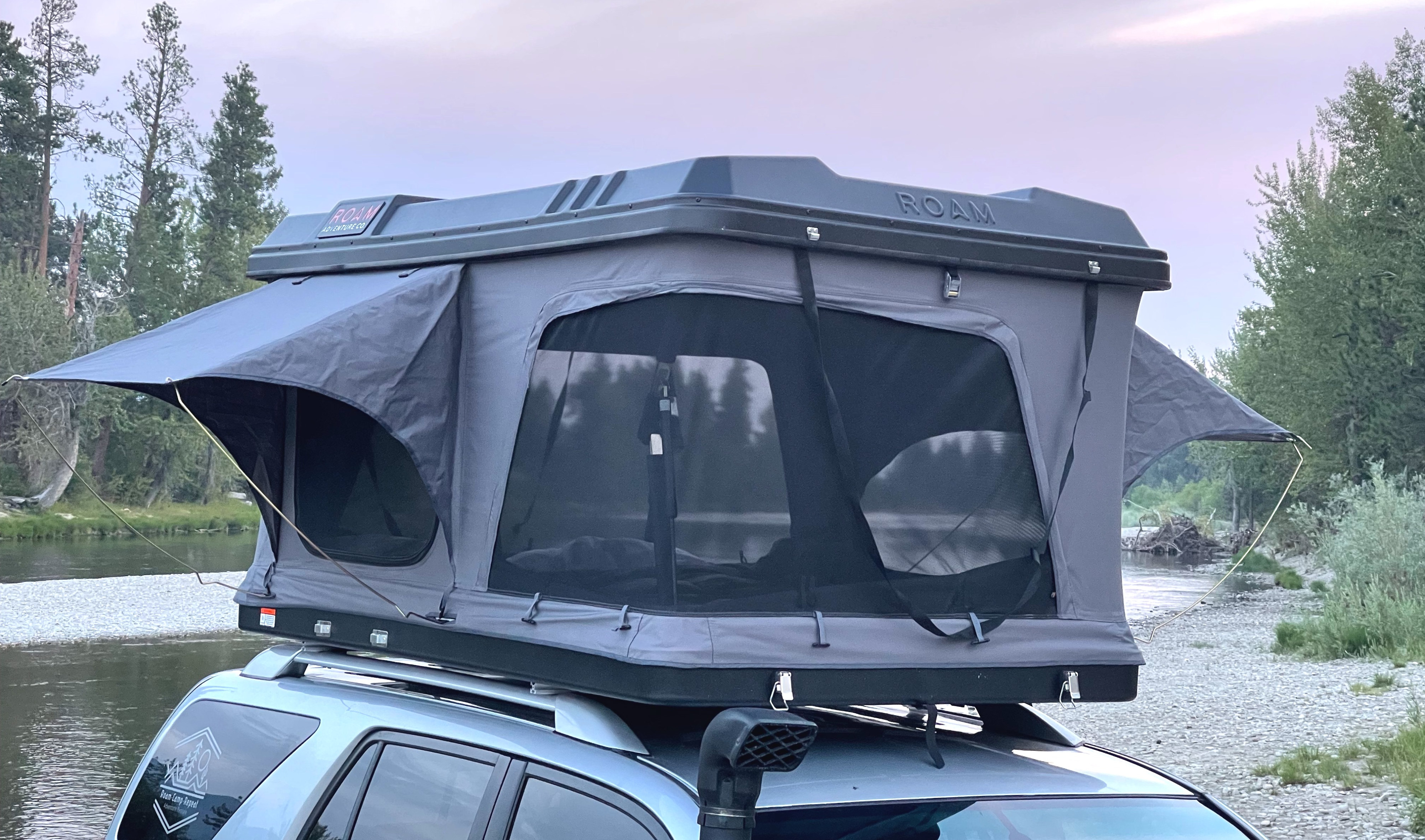 Adventure-ready RV rental! This Roam rooftop tent on an SUV by a river is perfect for camping and overlanding.. Toyota 4 Runner 2003